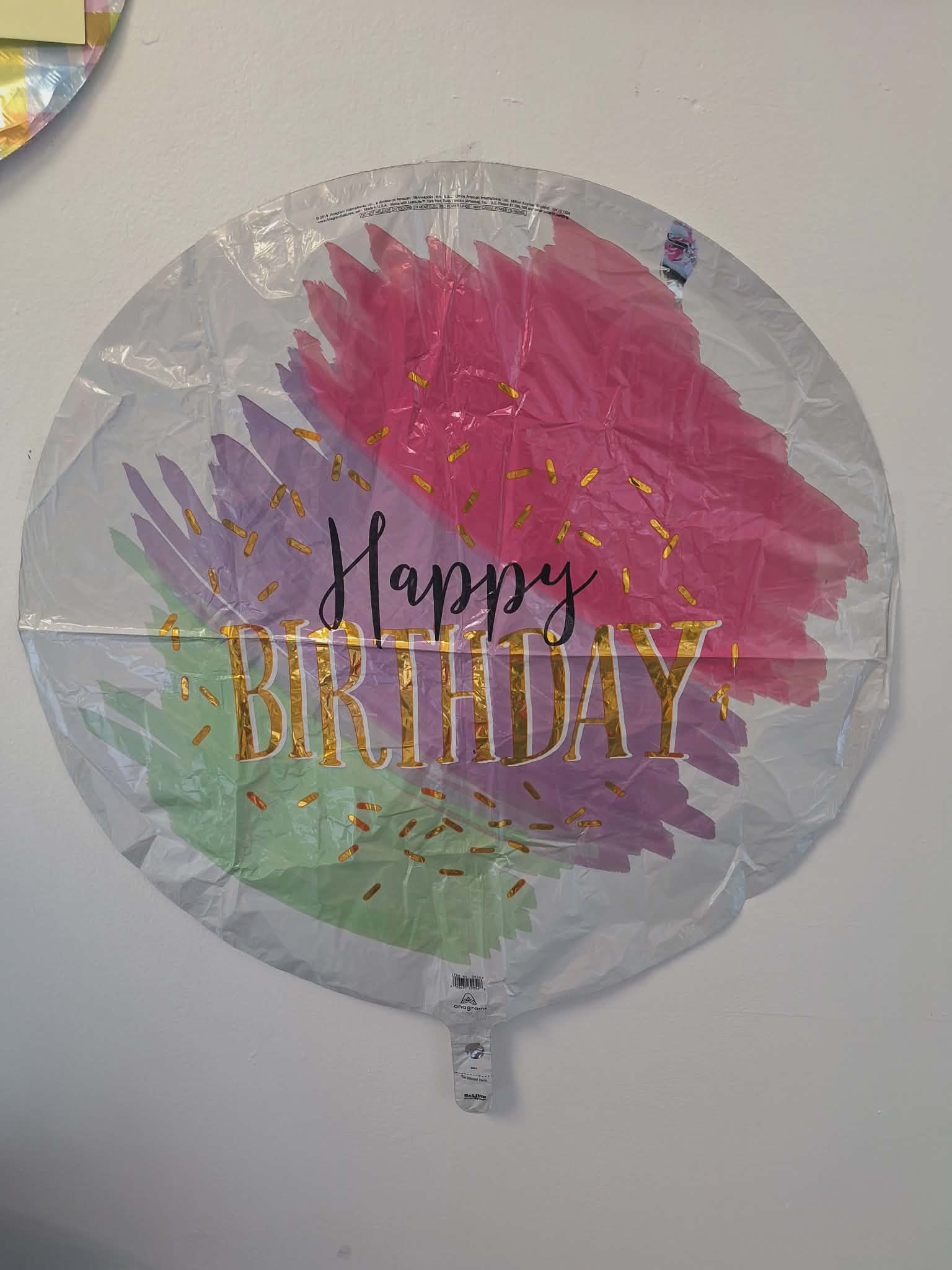 Round foil Happy Birthday balloon with pink, purple, and green brushstroke design