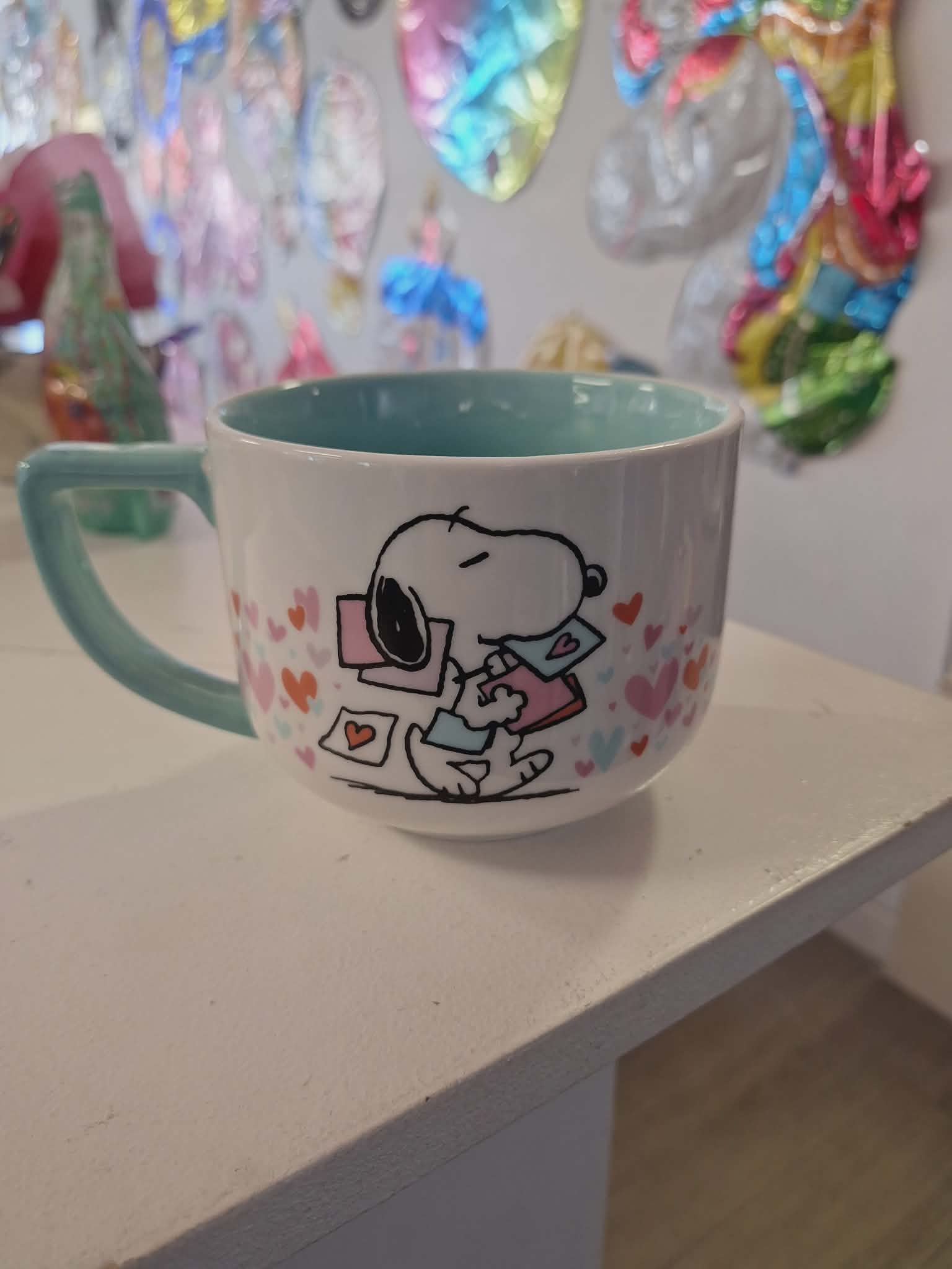 Ceramic mug with a Snoopy heart design and teal handle