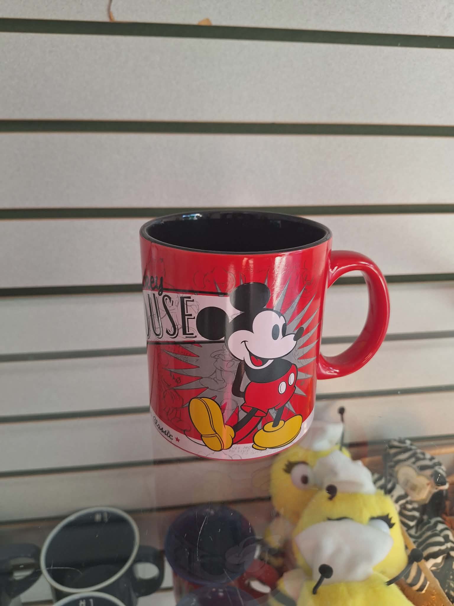 Red Mickey Mouse mug with a black interior on a shelf
