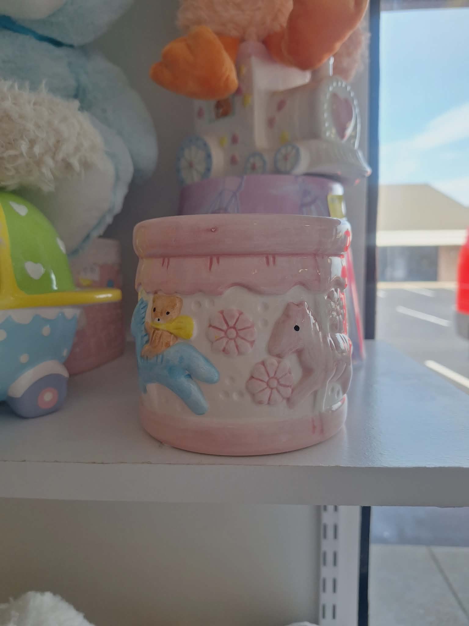 Pink ceramic jar with a teddy bear and horse reliefs