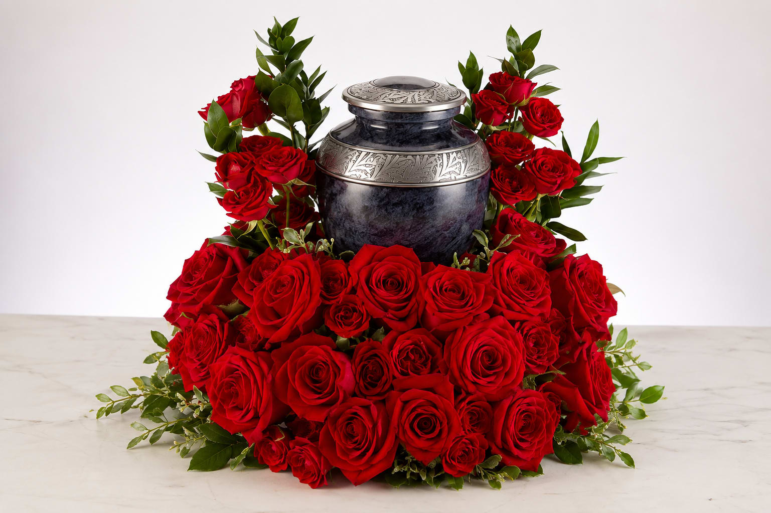 Red roses arranged around a decorative urn