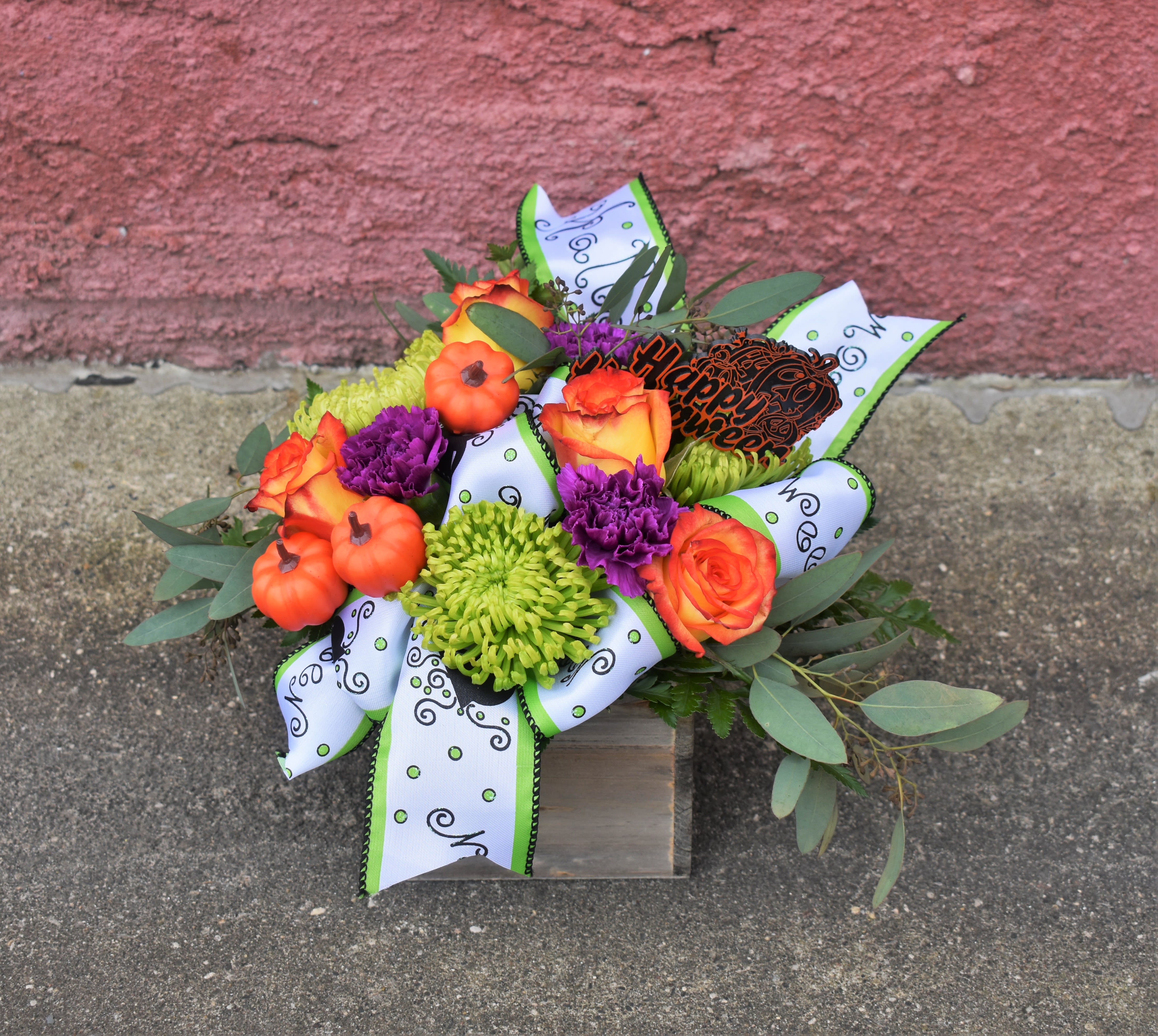 Hocus Pocus - A delightful treat to send someone to celebrate Halloween! Bright green spider mums, orange roses, and purple carnations are designed in a wooden box container and accented with Halloween "Cauldron" ribbon. 