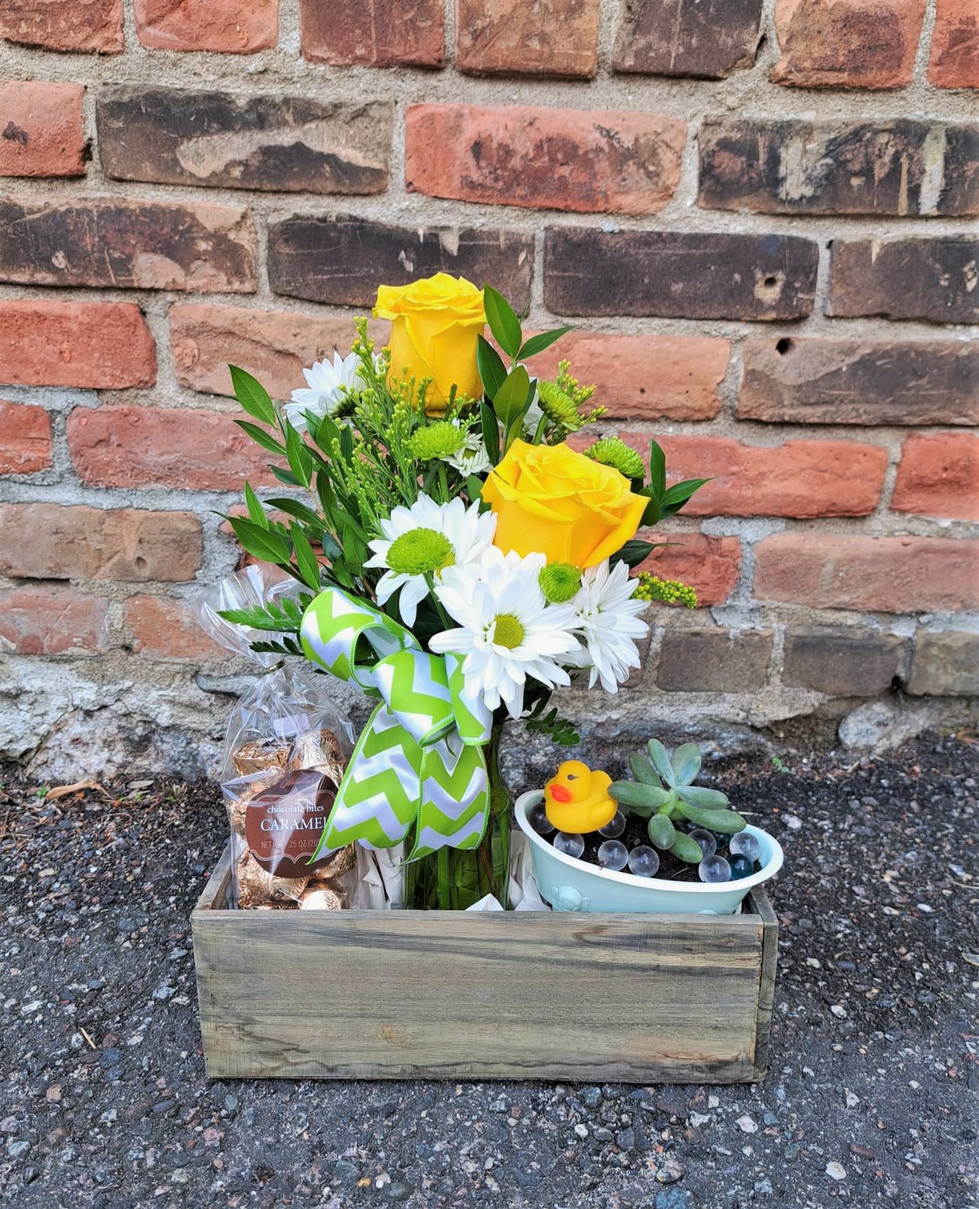 Yellow roses and white daisies in a wooden gift box with candy and a small succulent pot