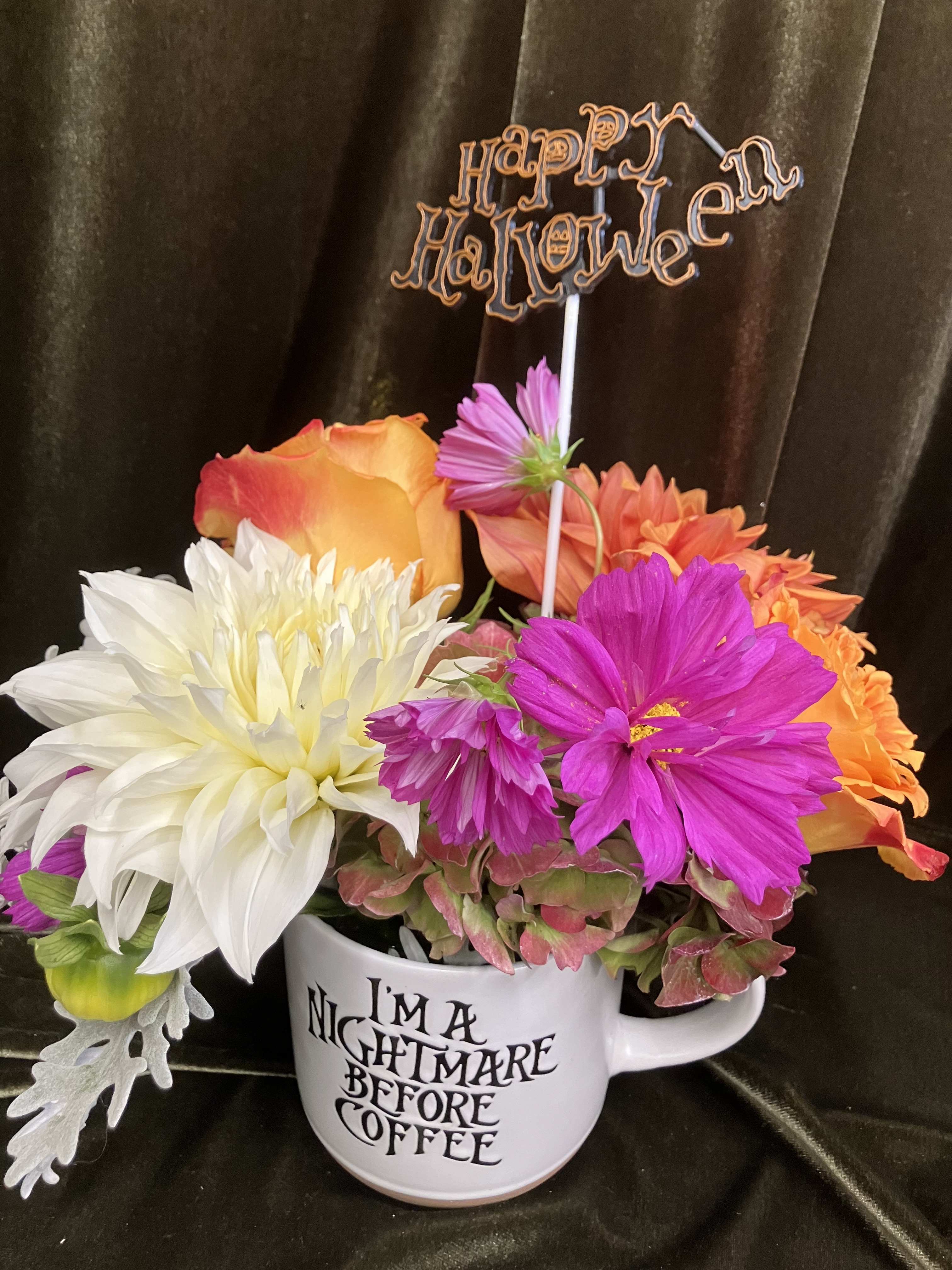 Colorful flower arrangement in a mug with Halloween signs