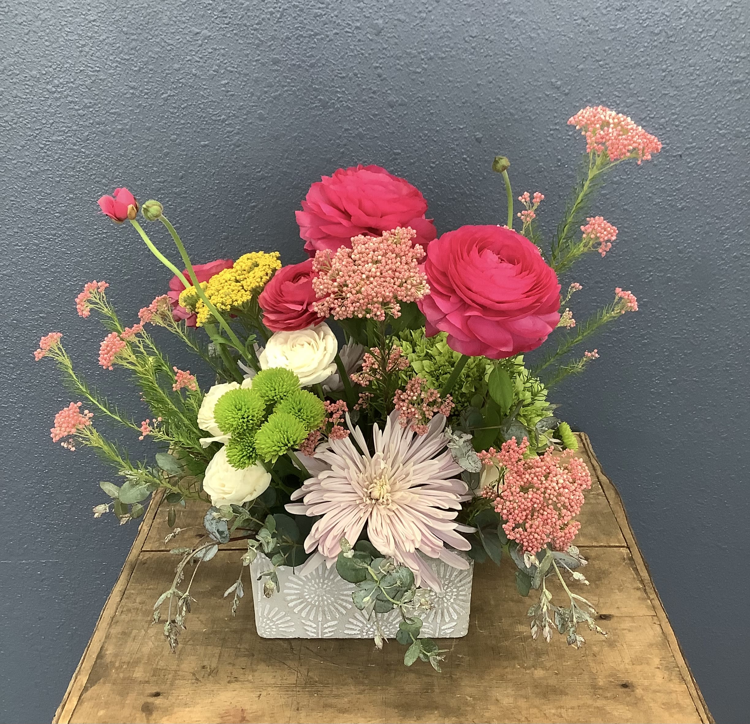 Mixed bouquet in a patterned rectangular vase with pink, white, and green blooms