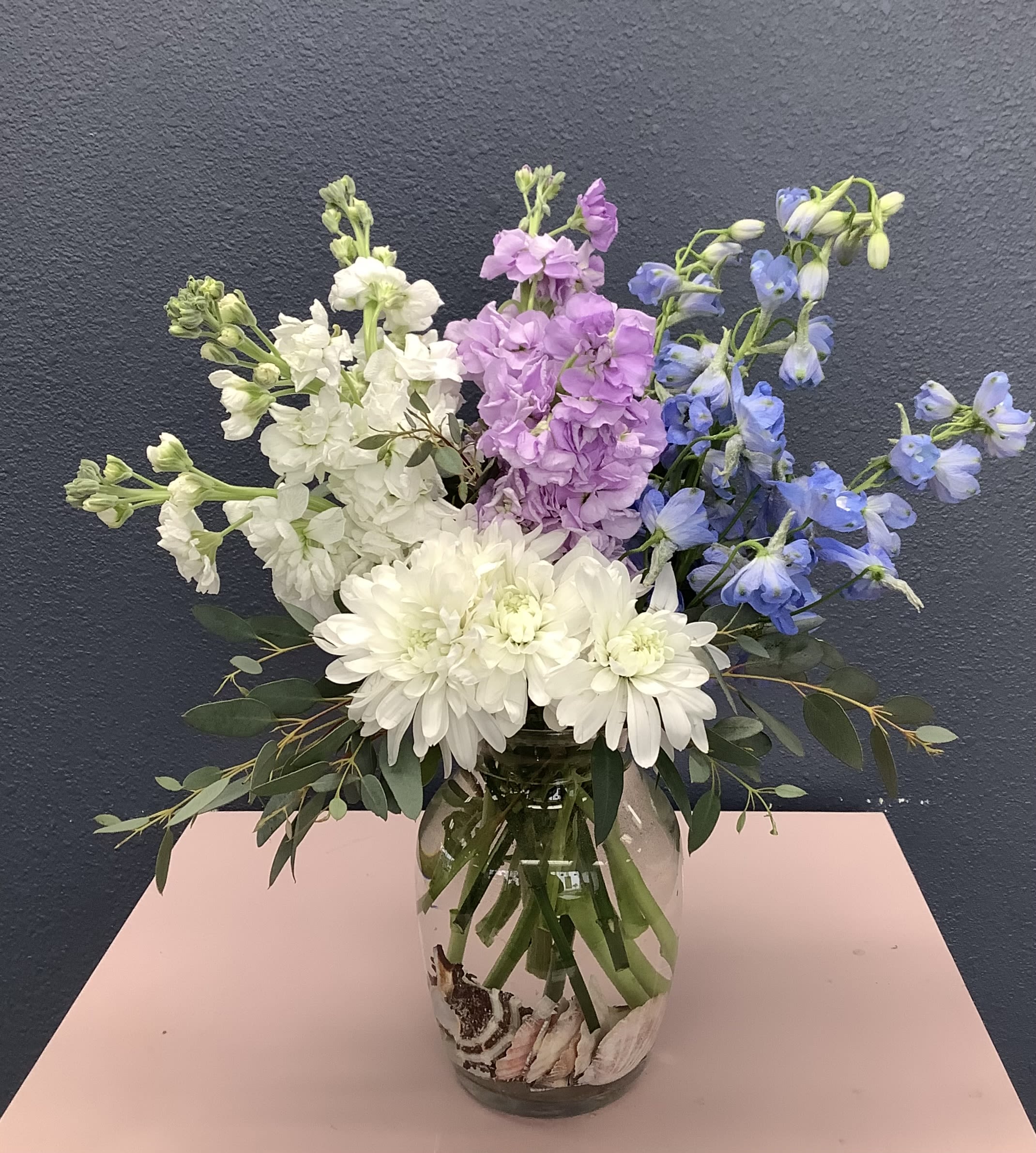 Bouquet of white, pink, and blue flowers in a glass vase