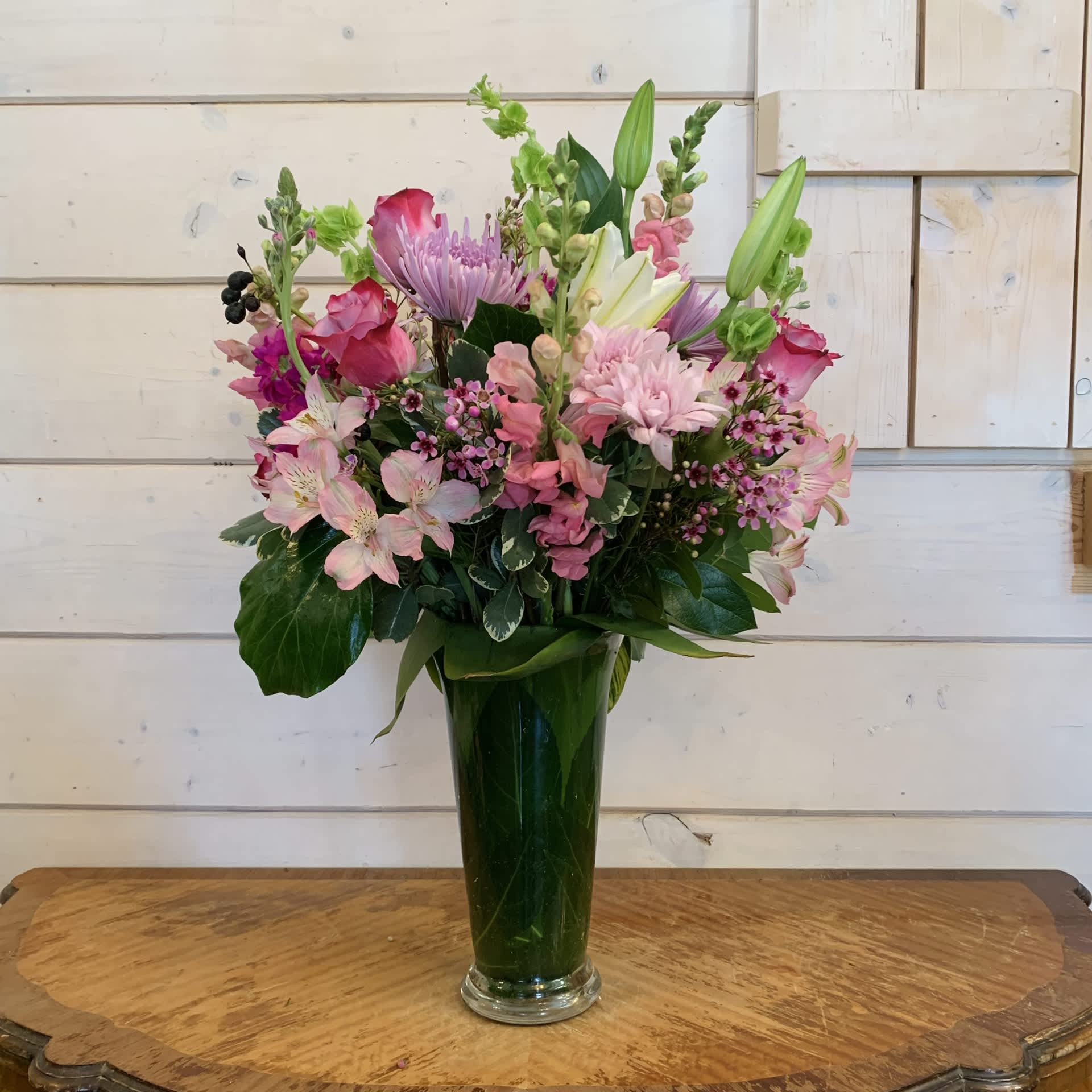 Mixed pink and lavender bouquet in a tall glass vase