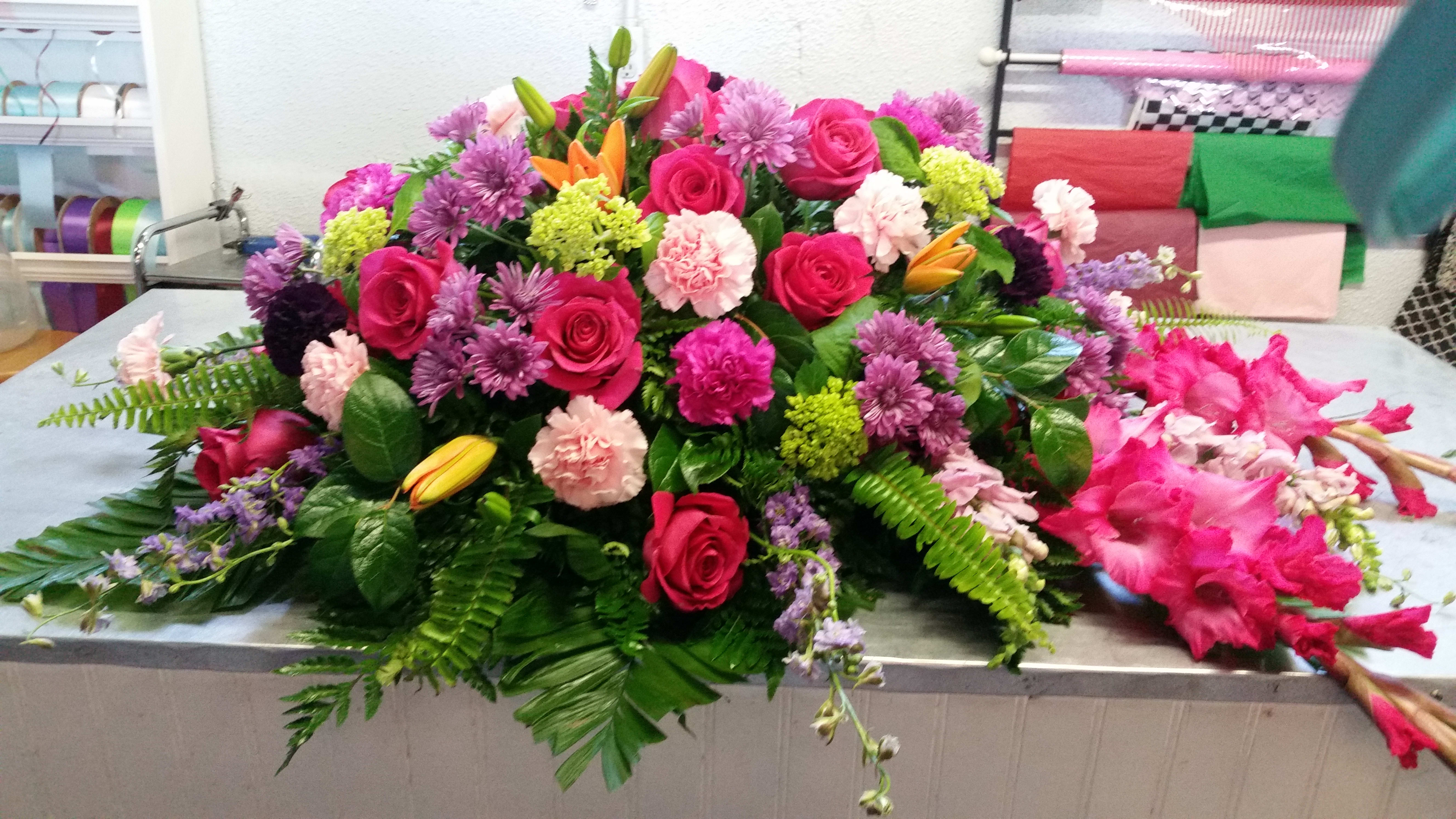 Large mixed floral arrangement with pink roses and purple blooms