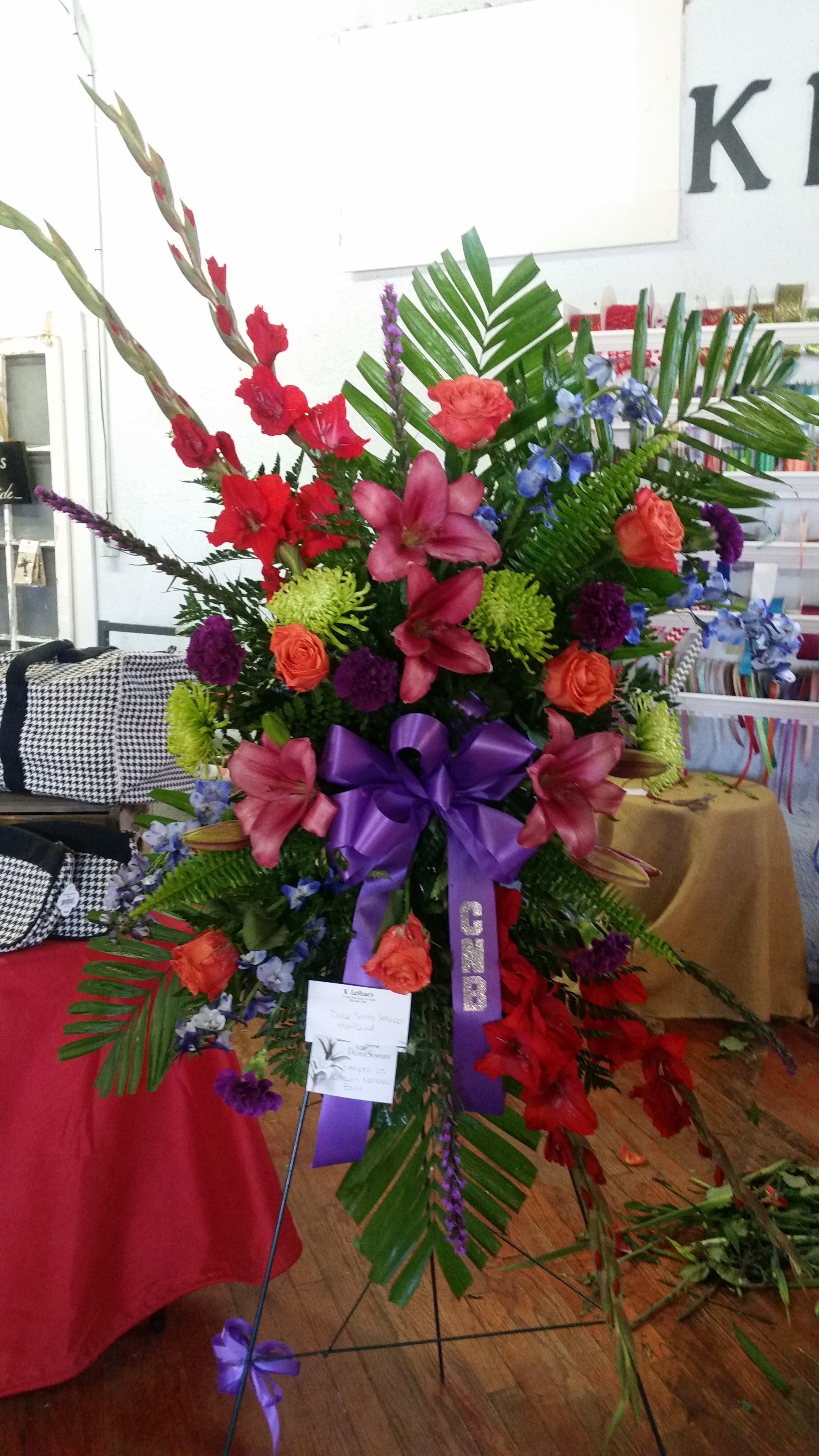 Large standing floral spray with red, pink, purple, and blue flowers