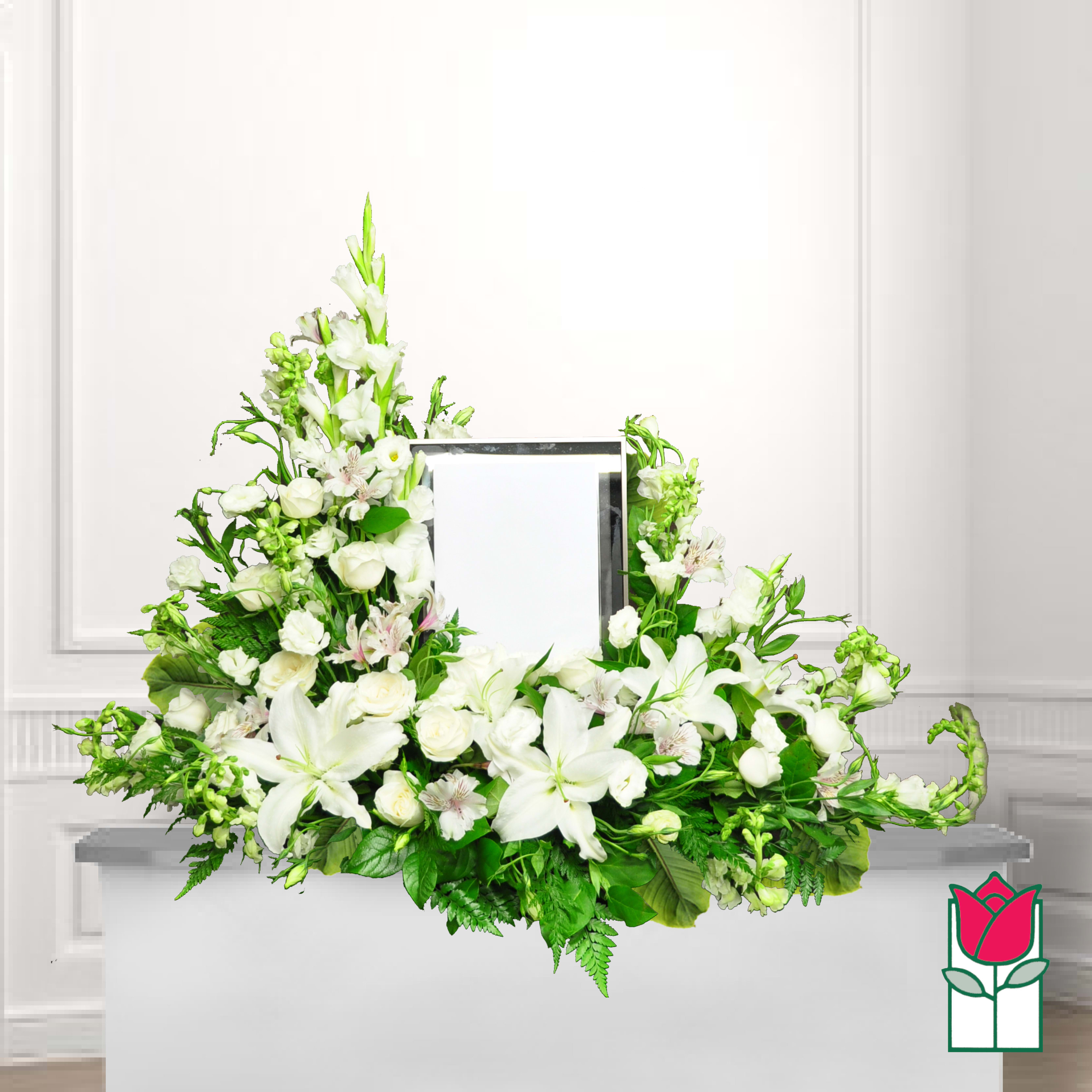 White floral funeral arrangement around a framed photo holder