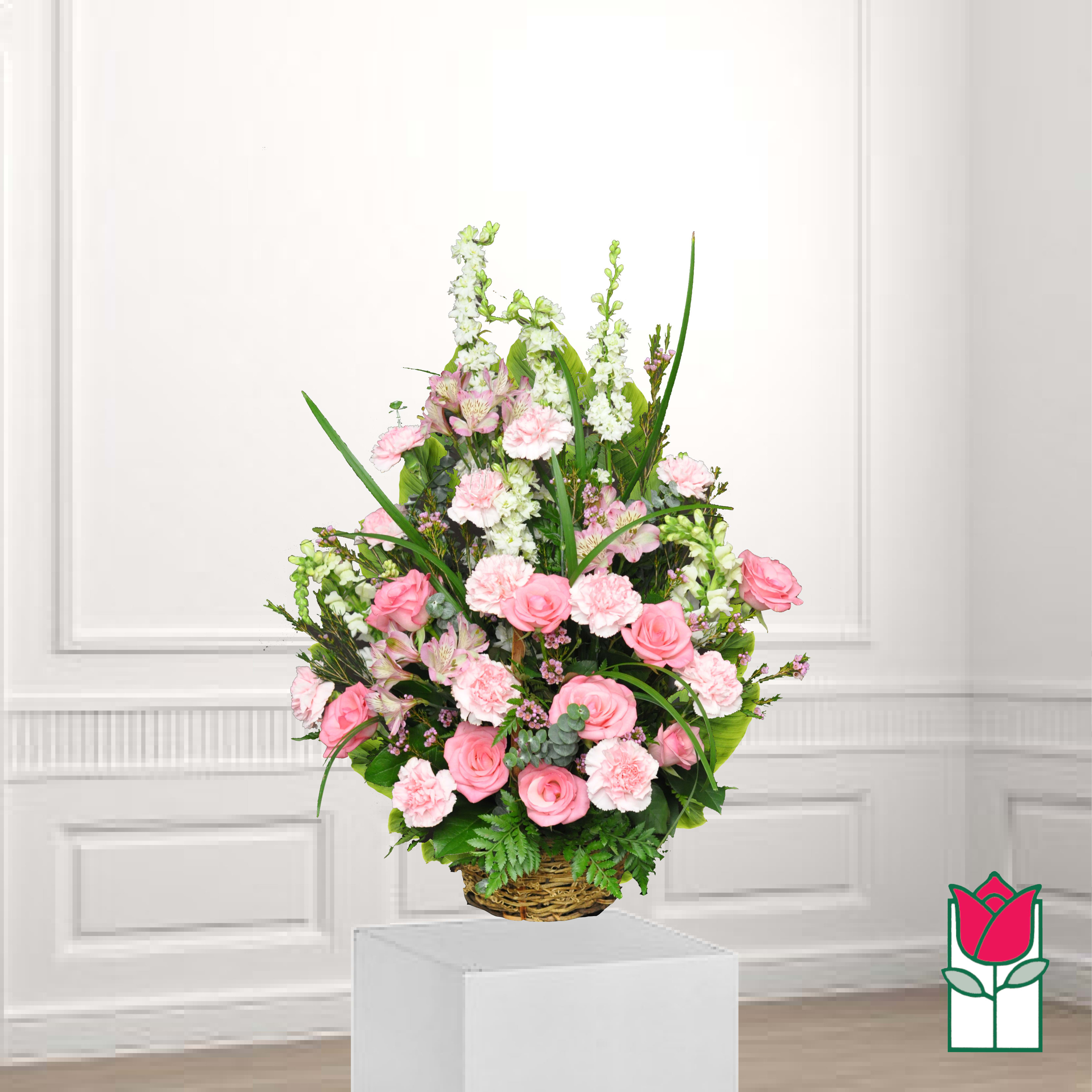 Pink roses and carnations in a wicker basket arrangement