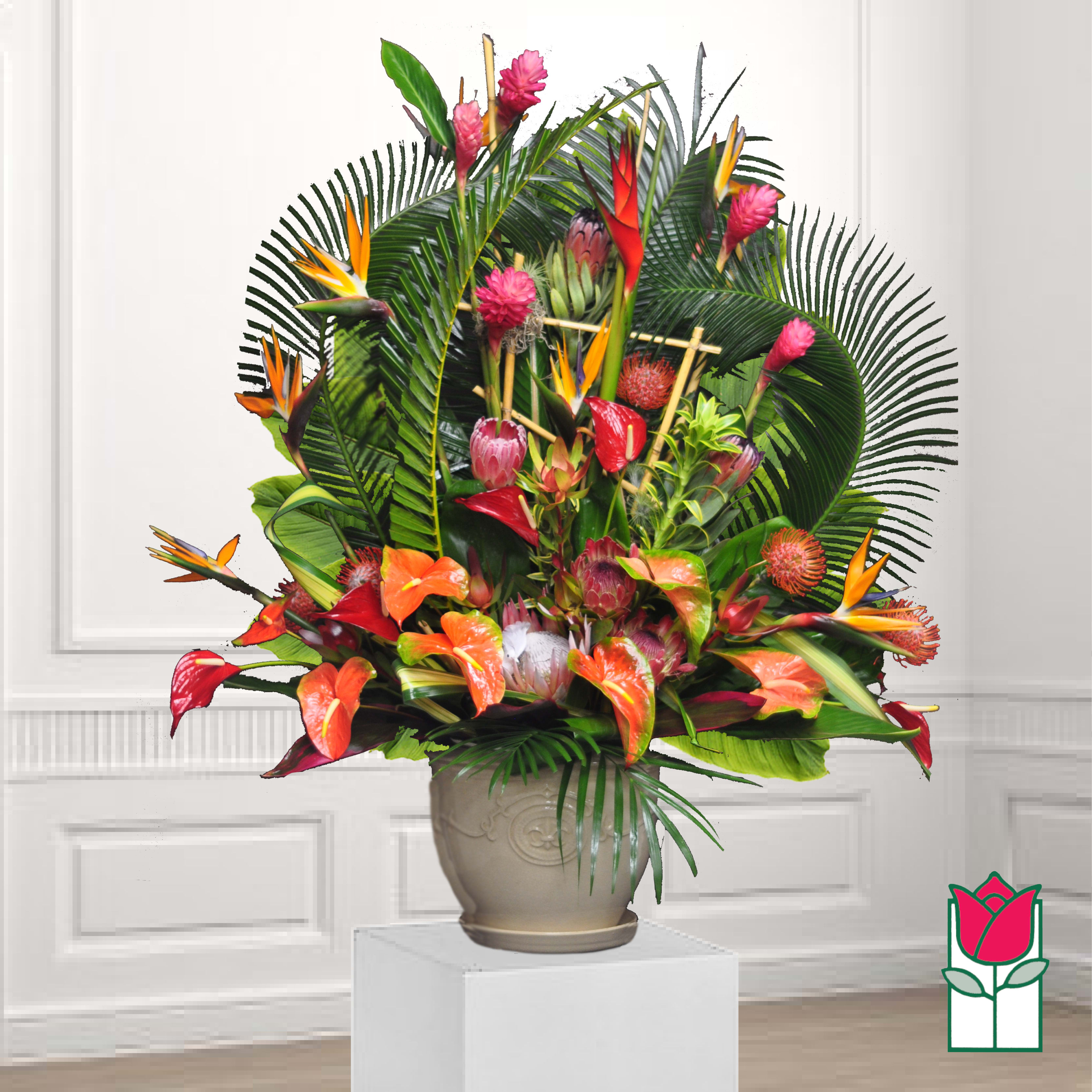 Tropical floral arrangement in a beige urn with orange and pink blooms