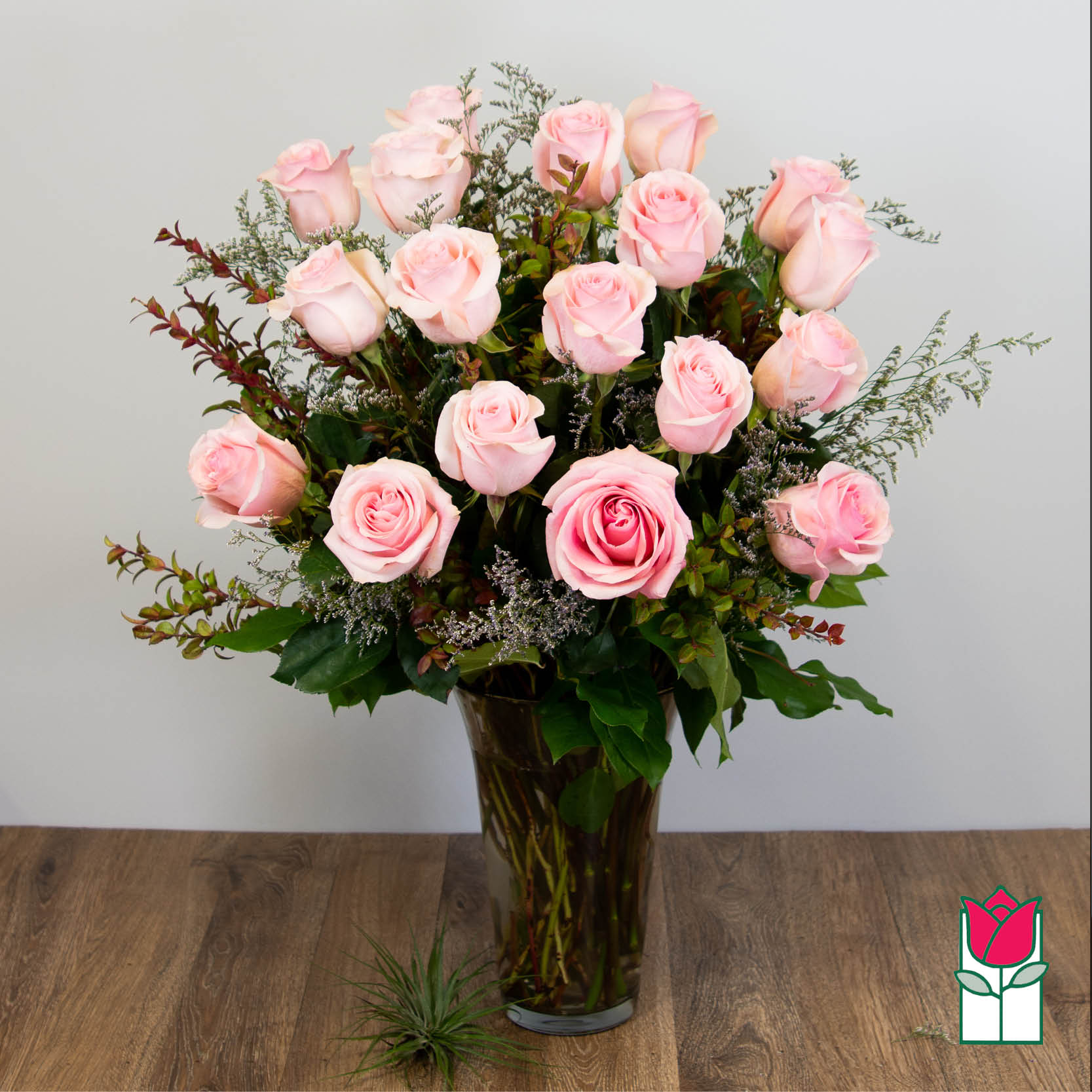 Pink roses arranged in a tall glass vase
