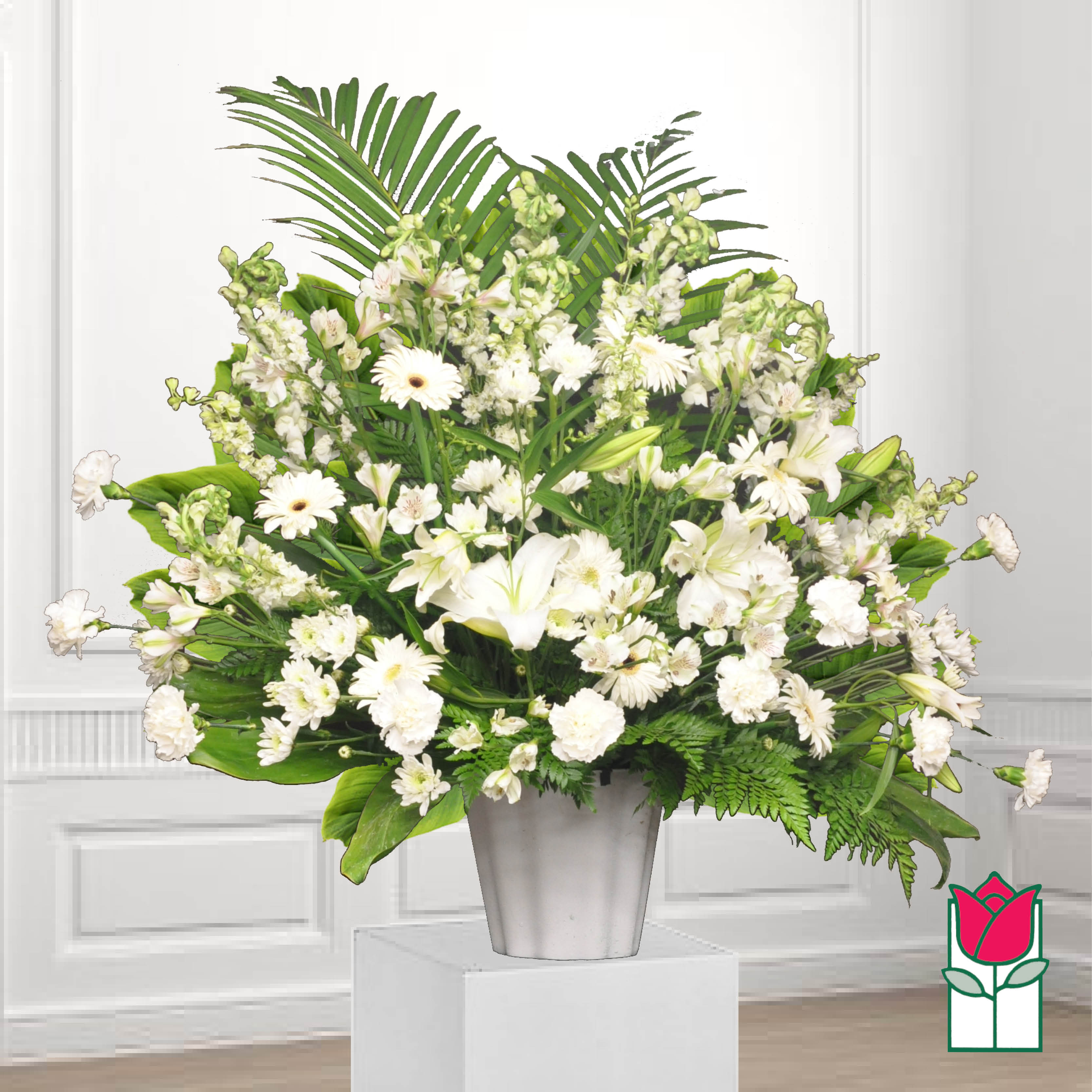 White floral arrangement in a silver vase with lush greenery