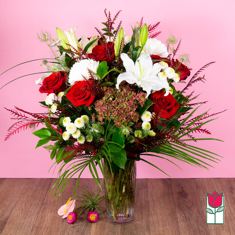 Bouquet of red roses and white lilies in a clear glass vase