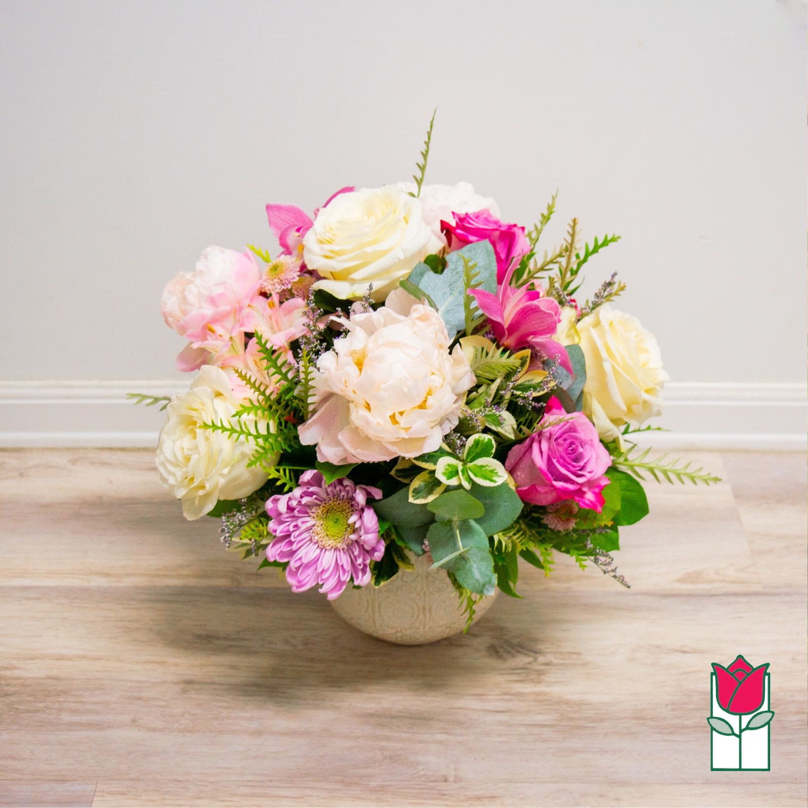 Mixed pink and white flower arrangement in a round vase
