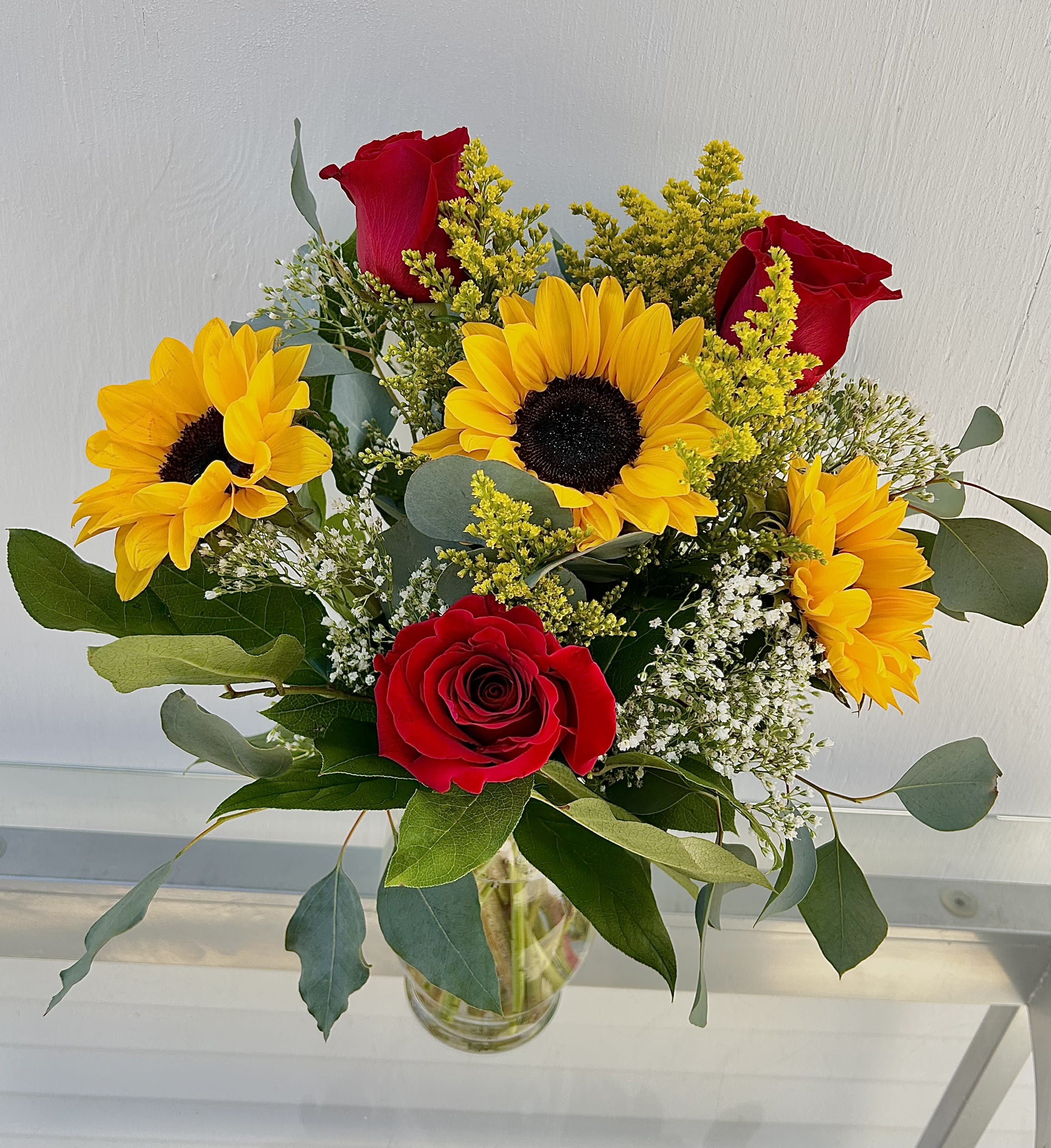 Sunflowers &amp; Roses - Sunflowers and red roses with accents of solid aster and babies breath in a clear vase