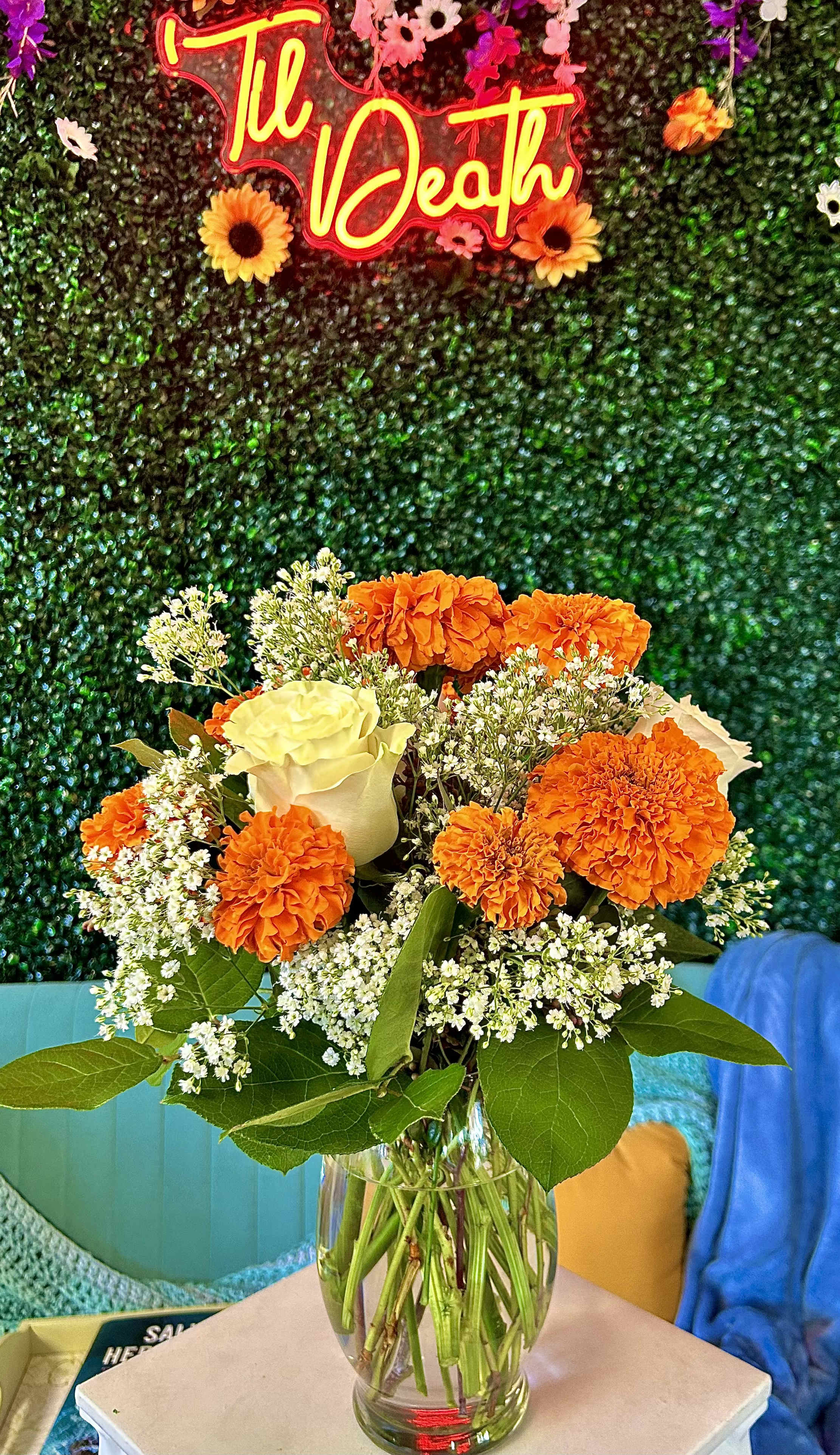 Orange marigolds and a white rose in a glass vase