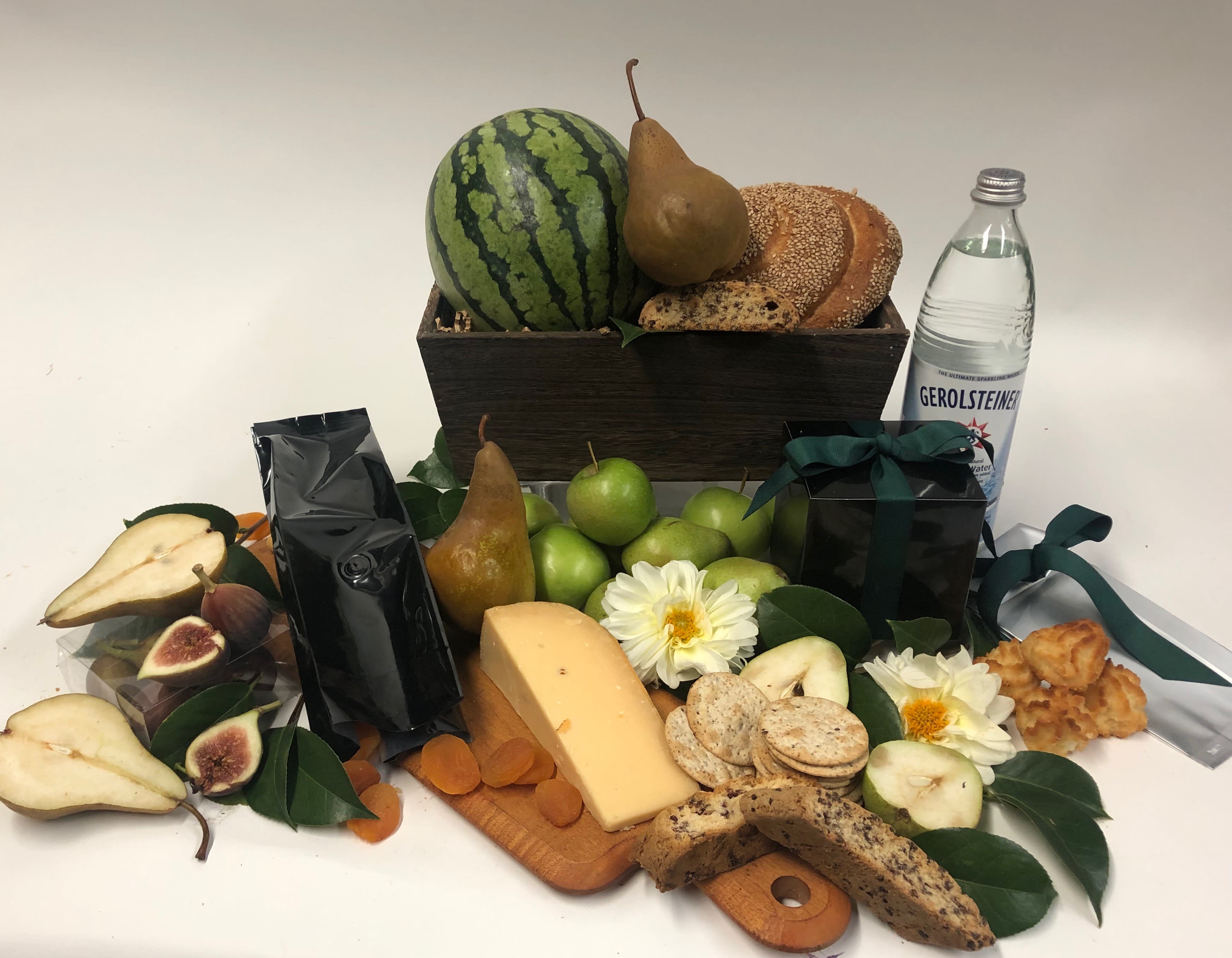 Fruit and cheese gift basket with bread, crackers, flowers, and a water bottle