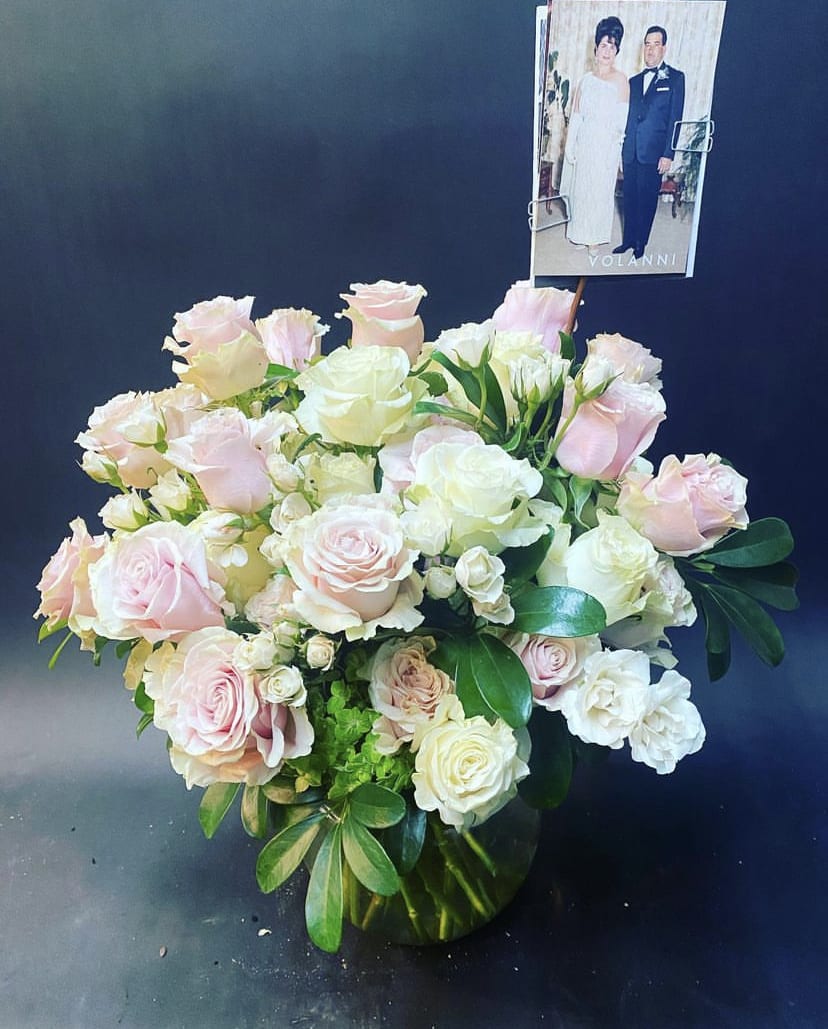 Bouquet of pale pink and white roses with a photo card