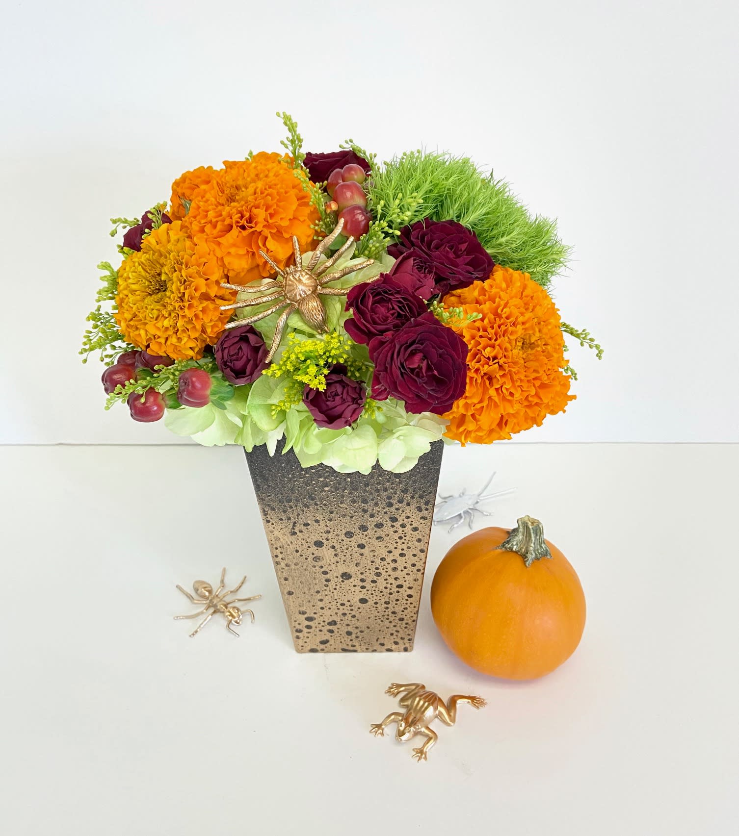 Jeepers Creepers - A fun design for the Spooky Cutie in your life! A custom painted container filled with seasonal marigolds, rich red spray roses, and textural dianthus...accented with a creepy little friend for Halloween!
