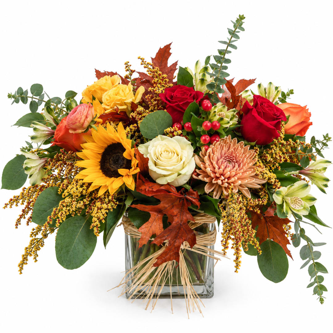 Autumn bouquet with roses, sunflower, chrysanthemum, and a glass vase