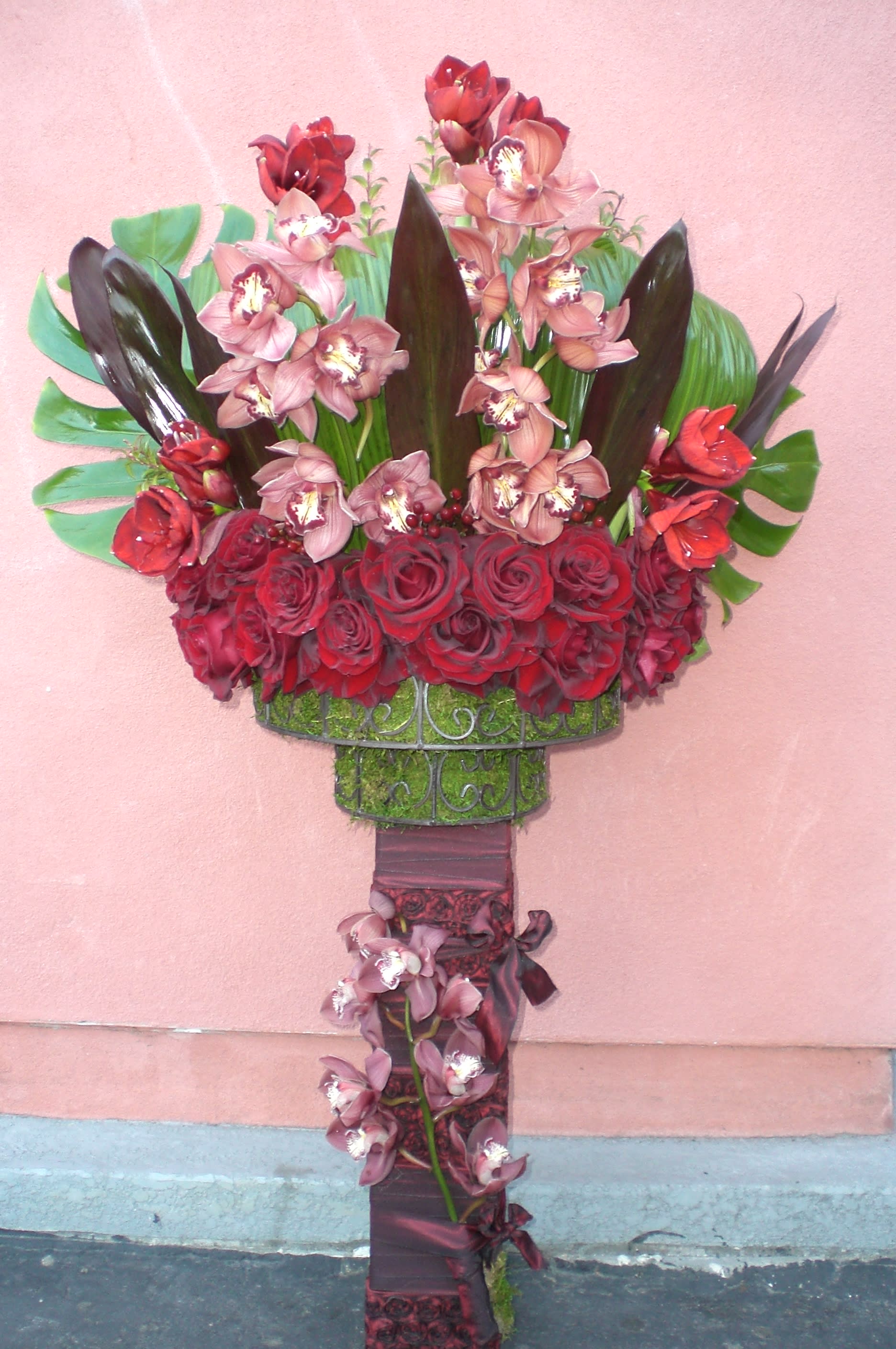 Tall standing floral arrangement with red roses and pink orchids