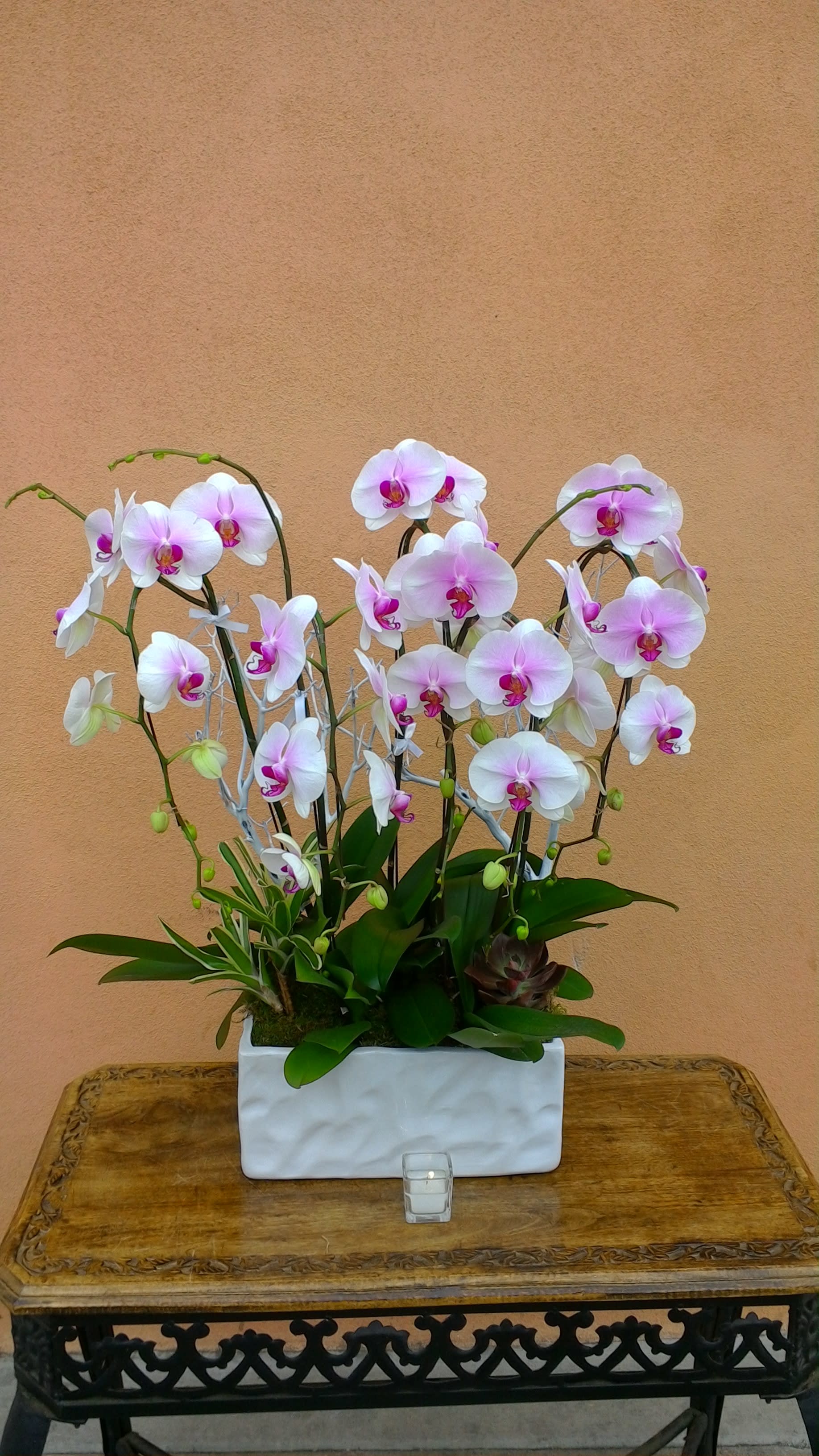 White and pink orchids arranged in a white rectangular planter