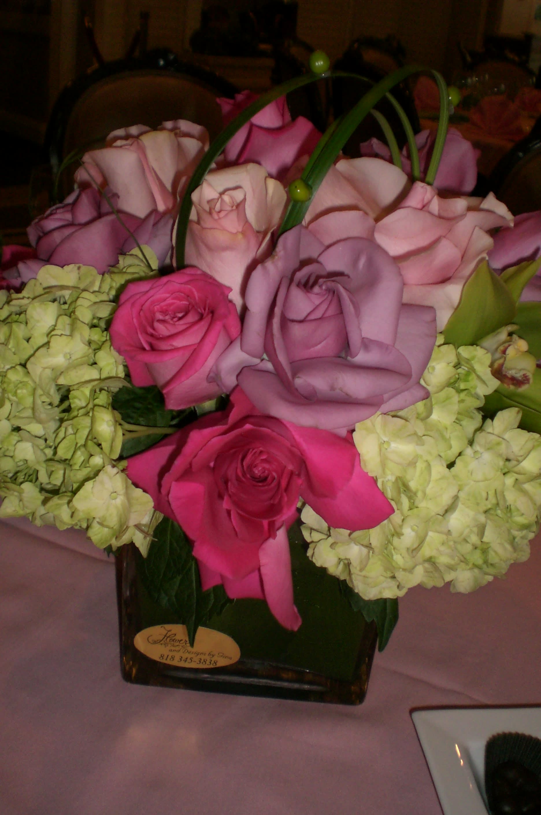 Pink and lavender roses with pale green hydrangeas in a square vase