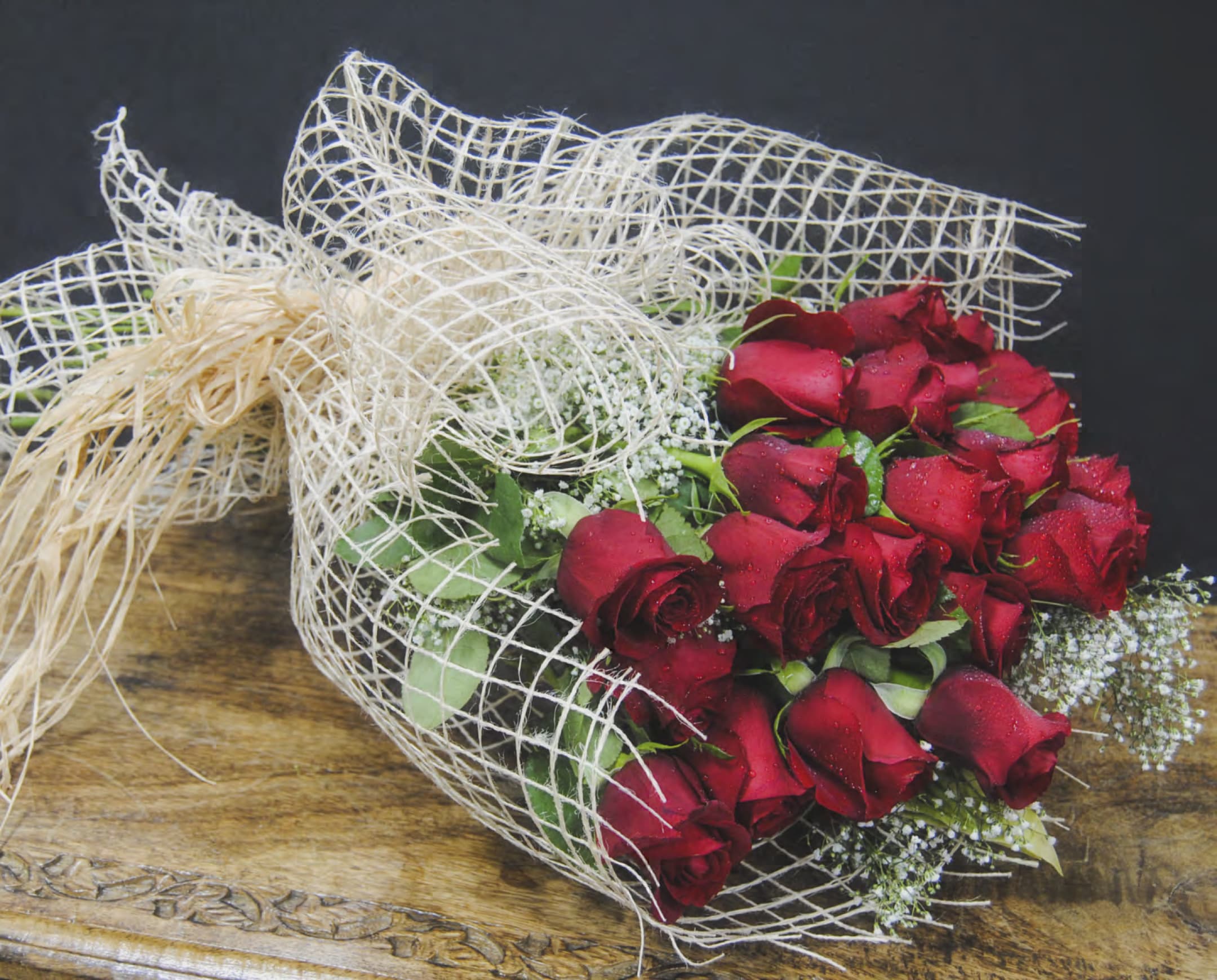 Bouquet of red roses wrapped in white mesh