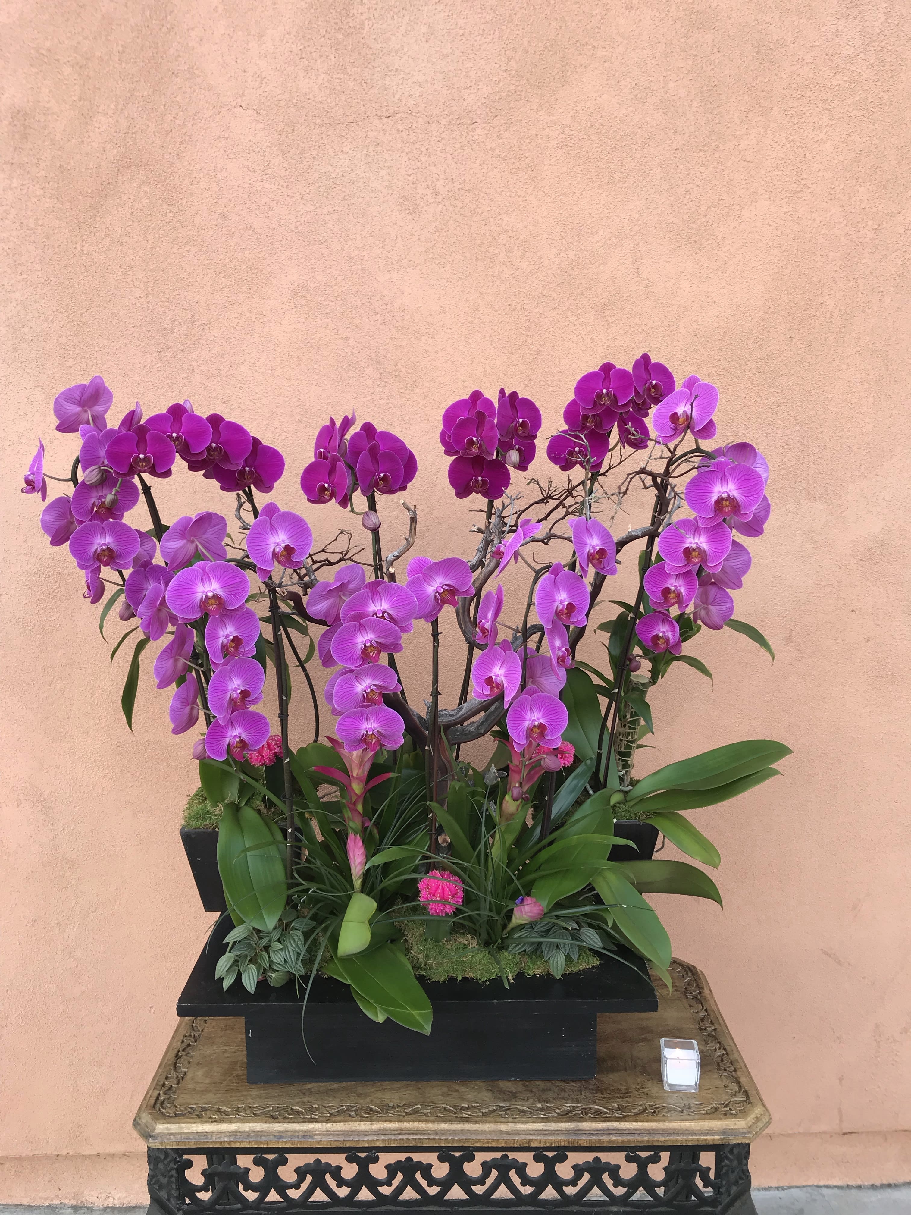 Purple orchid arrangement in a black rectangular planter