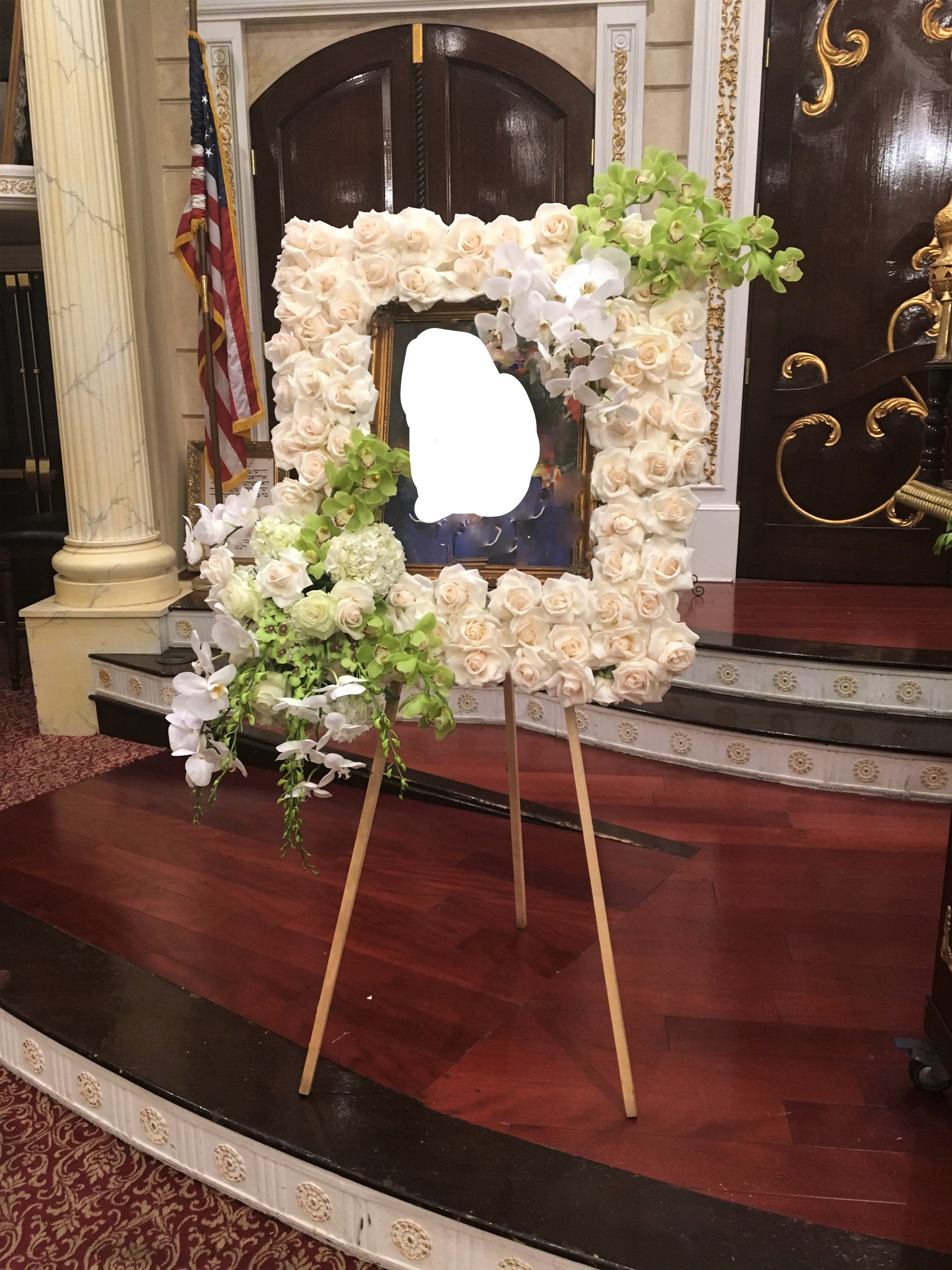 Large floral easel display of white roses and orchids