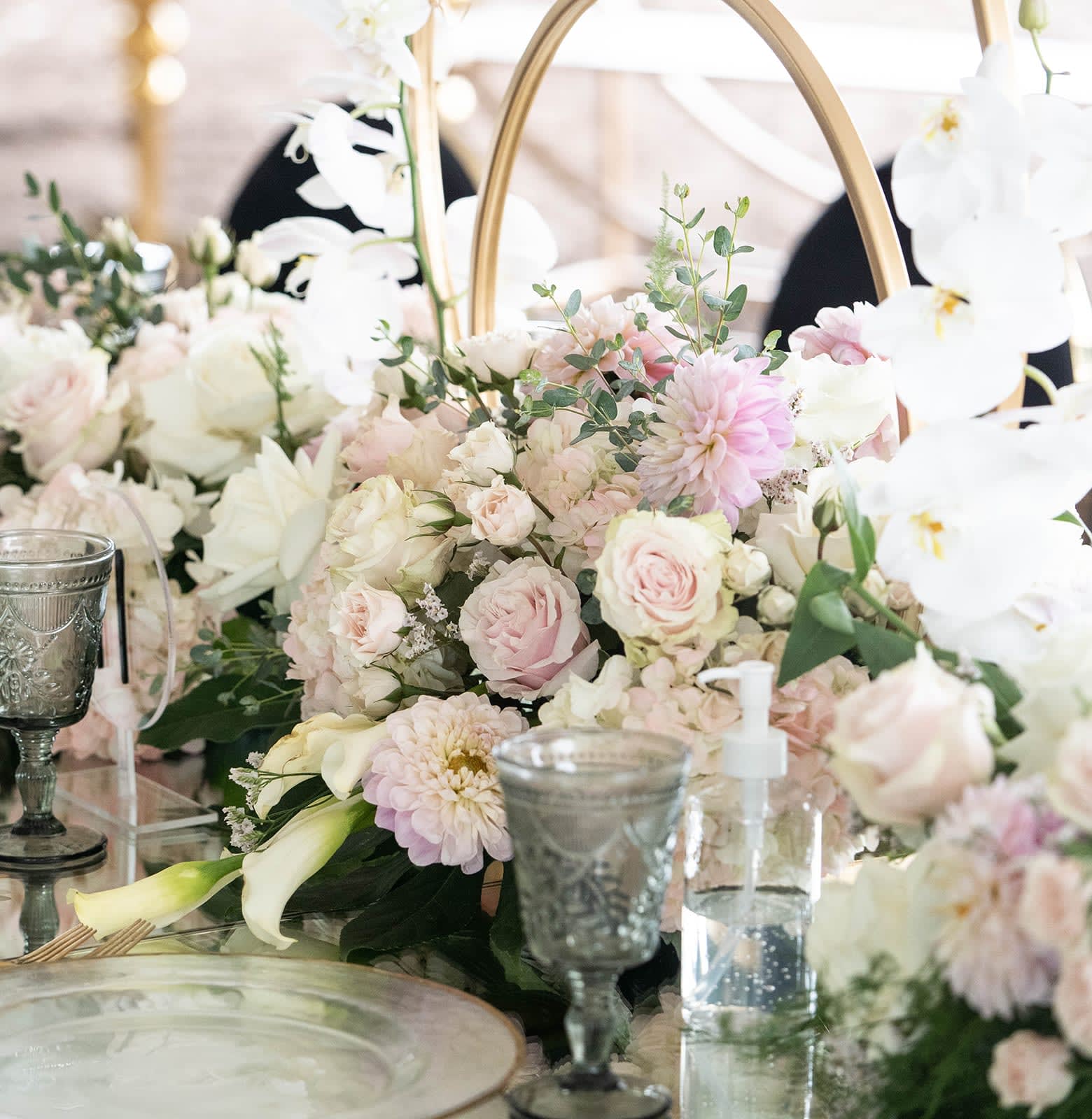Pastel floral centerpiece with roses, dahlias, and white orchids
