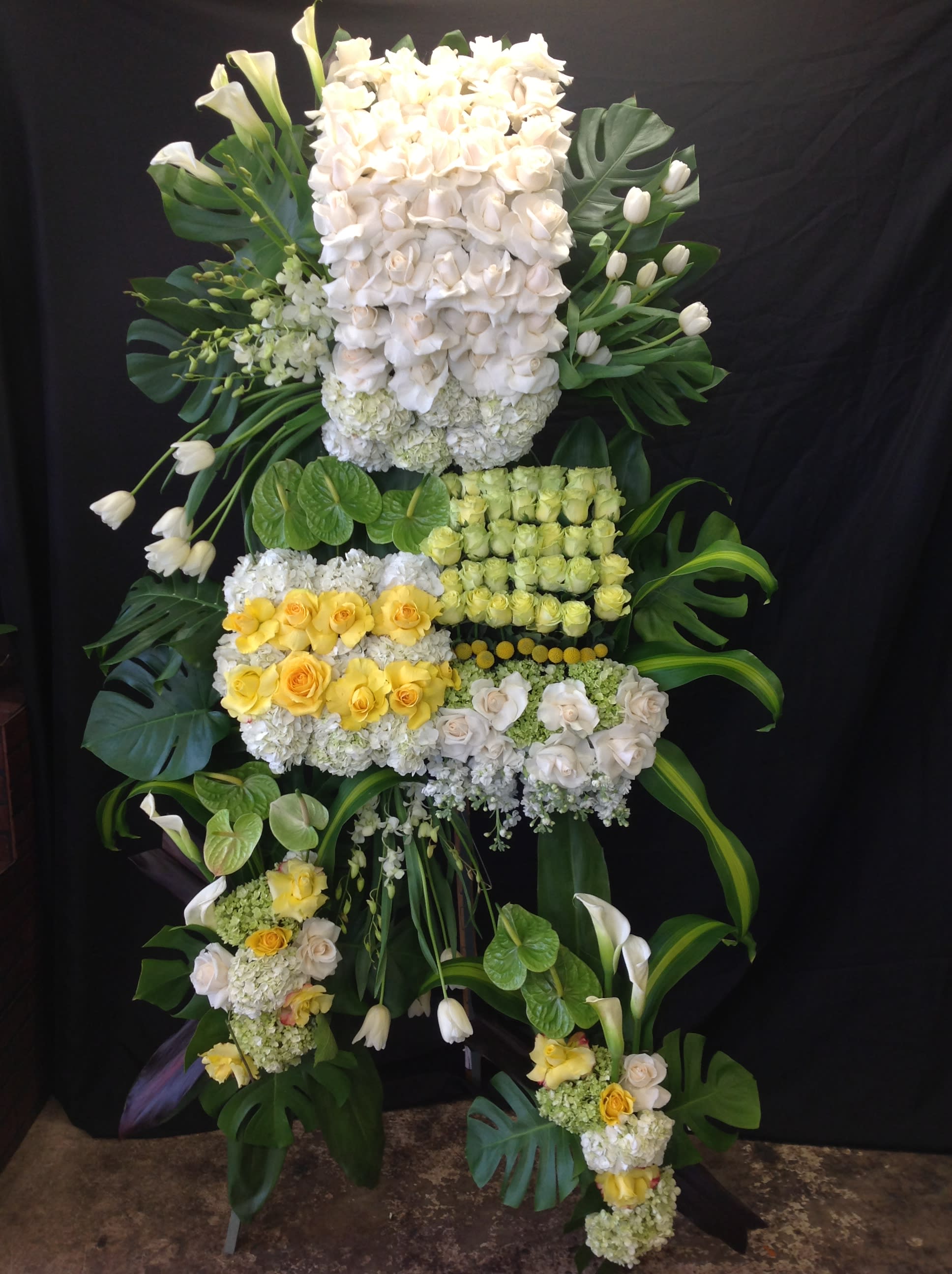 Large floral standing arrangement with white and yellow roses and calla lilies
