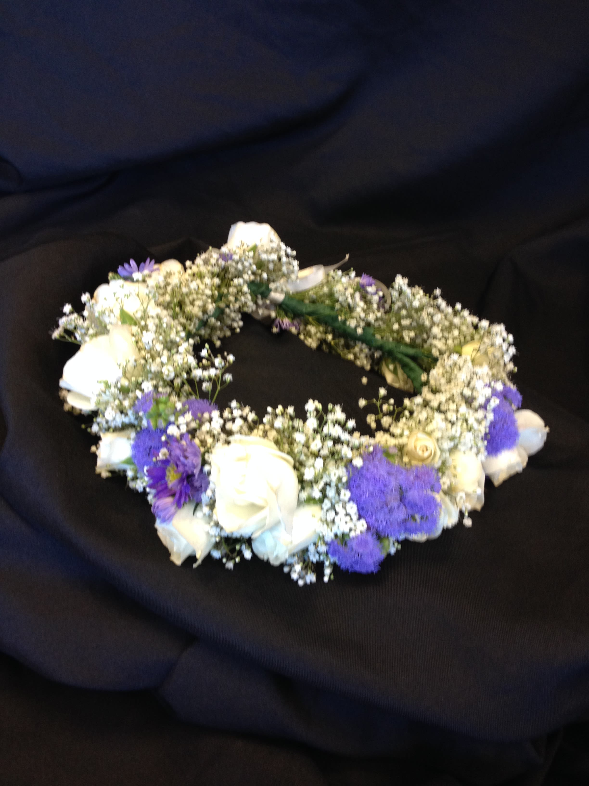 White and purple floral wreath on a black background