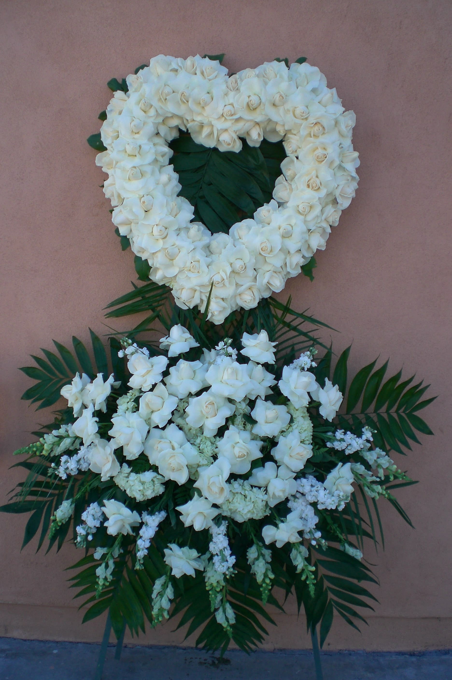 White floral funeral wreath with a matching spray below