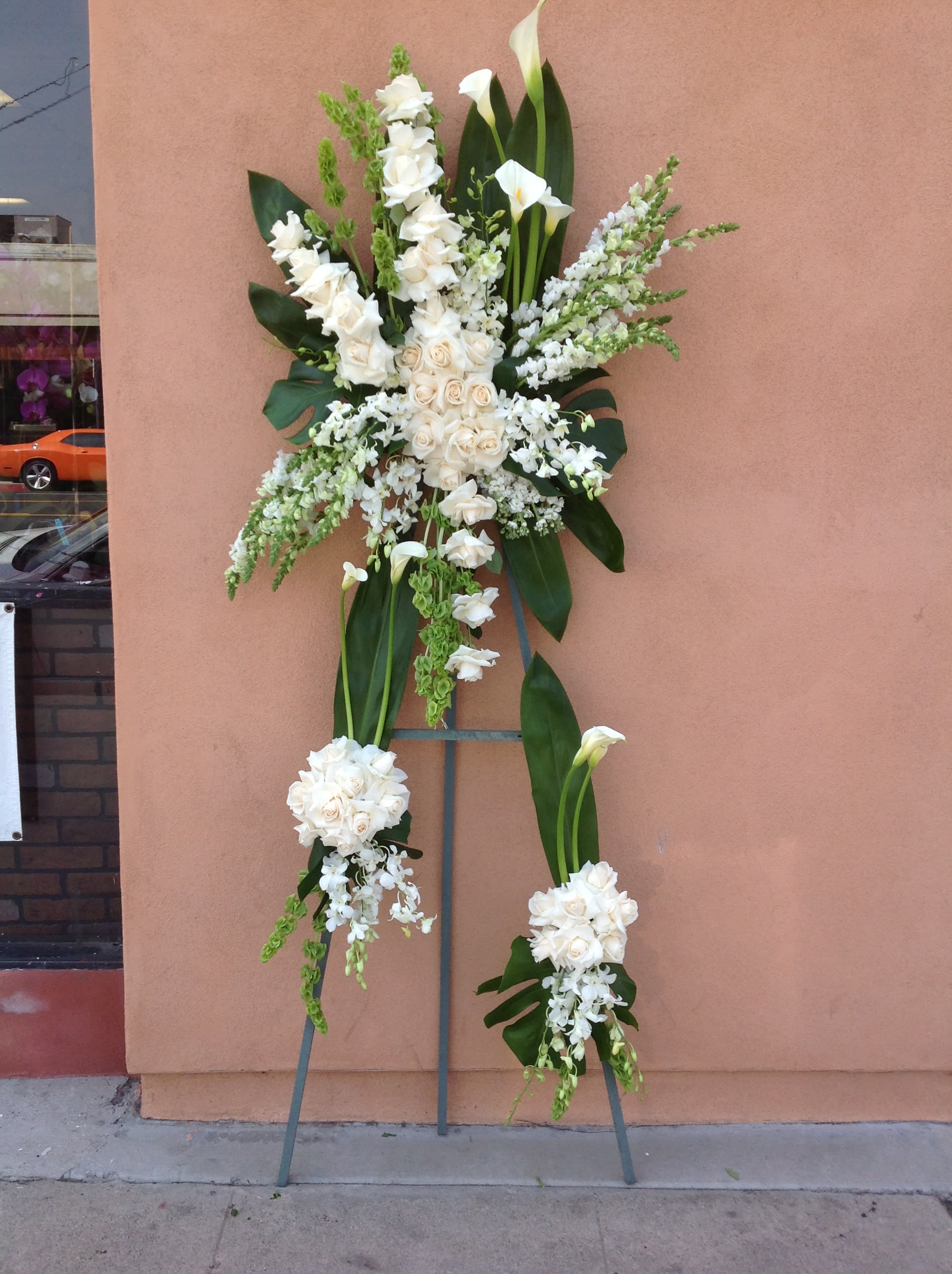 Tall white floral standing spray on a metal easel
