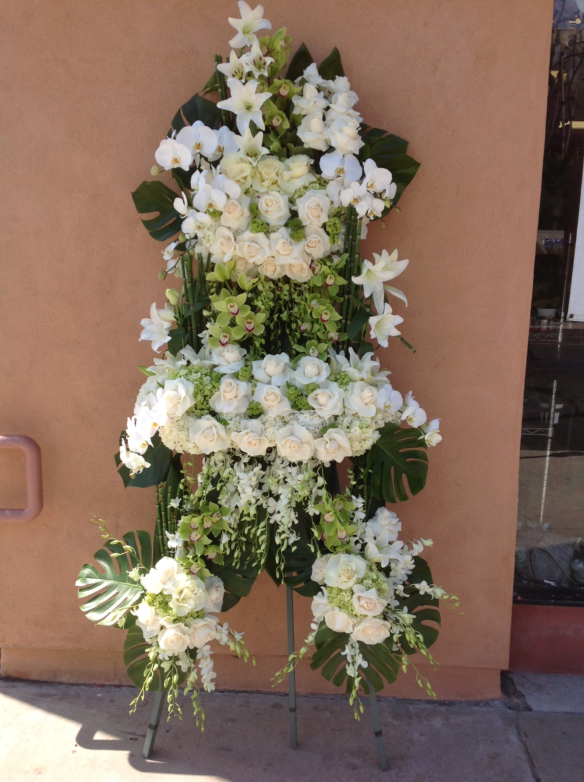 Tall white floral standing spray with roses and orchids