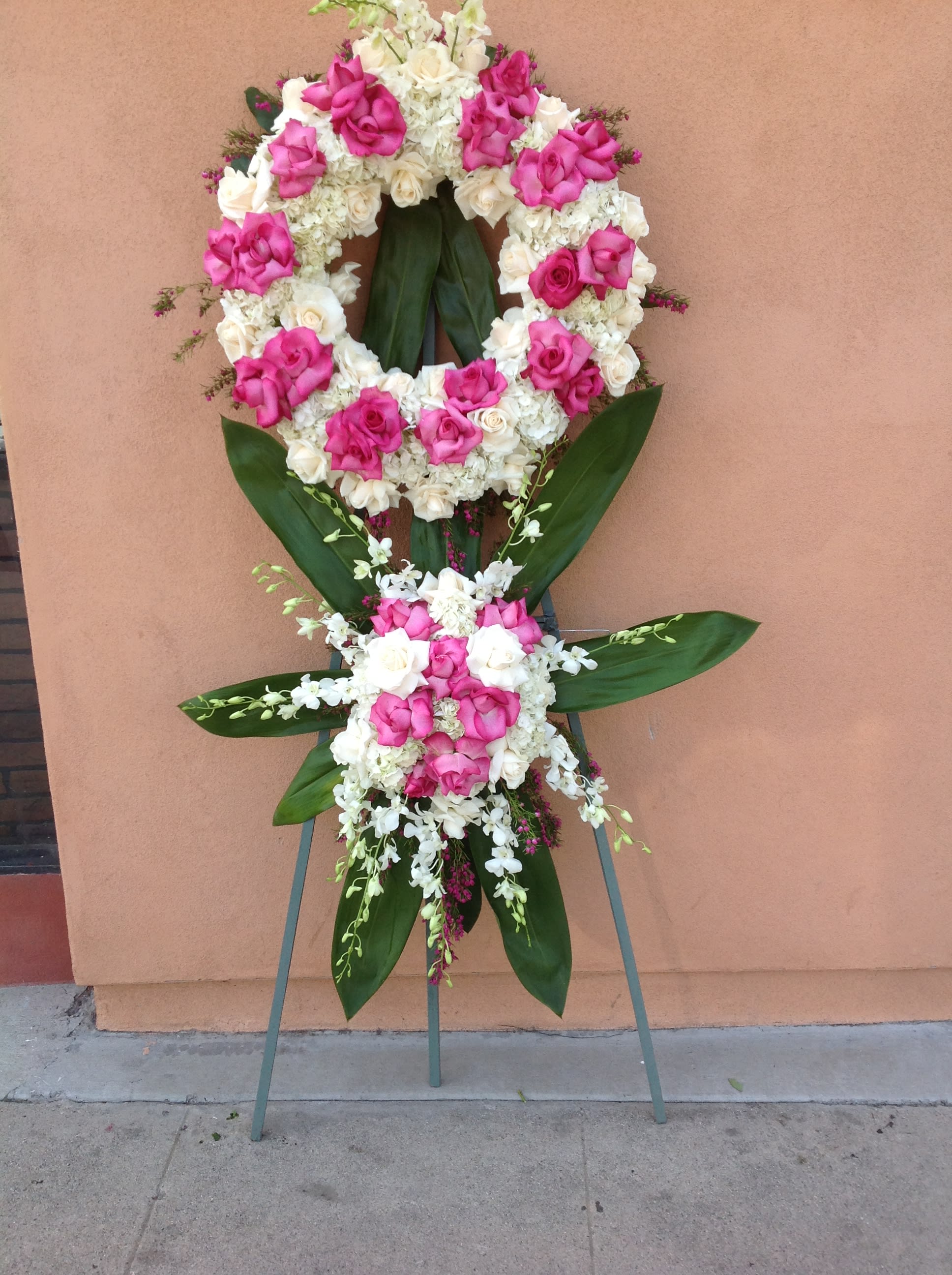 Standing floral wreath of pink and white roses on an easel