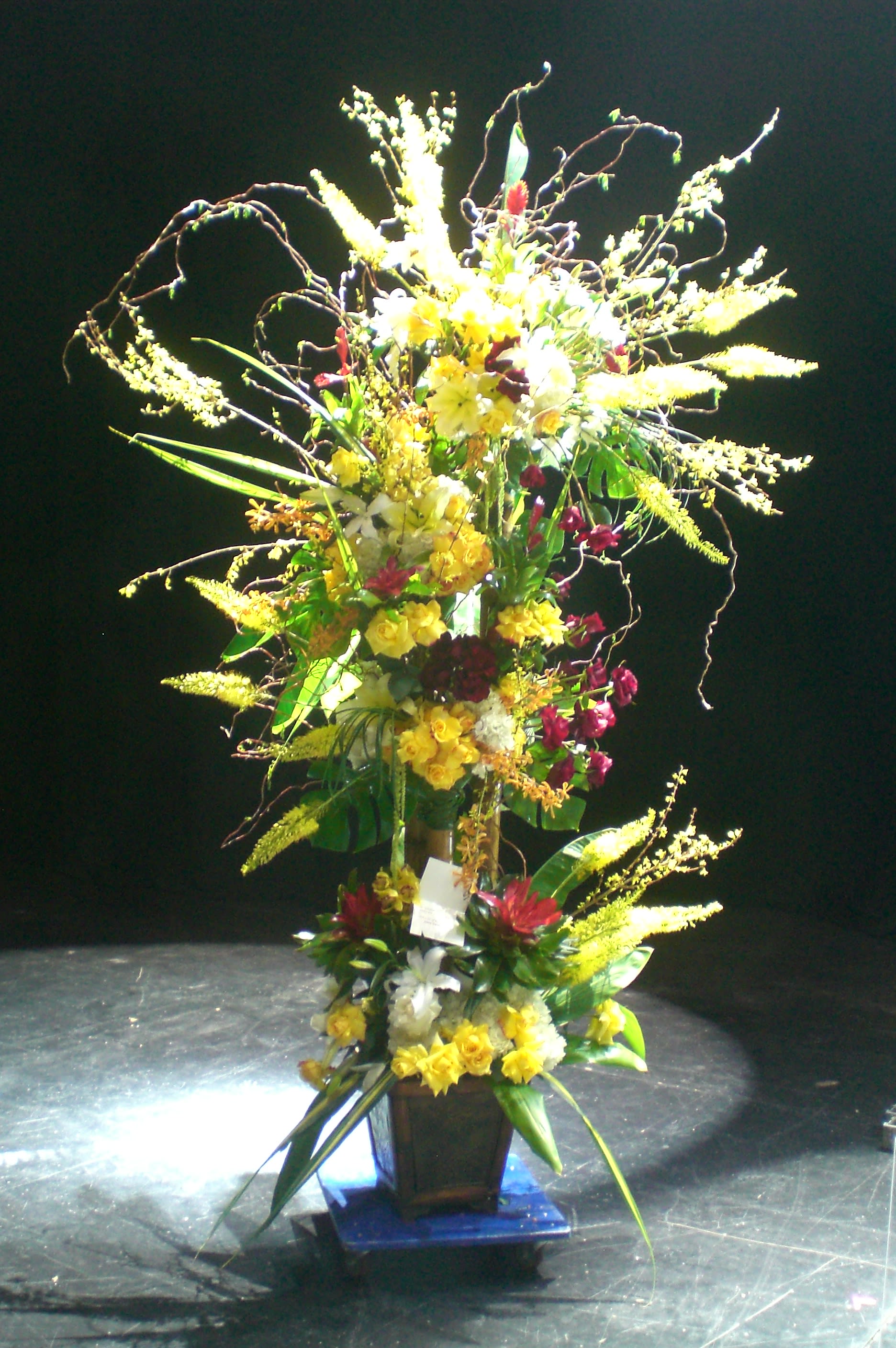 Tall floral arrangement with yellow and white blooms in a vase
