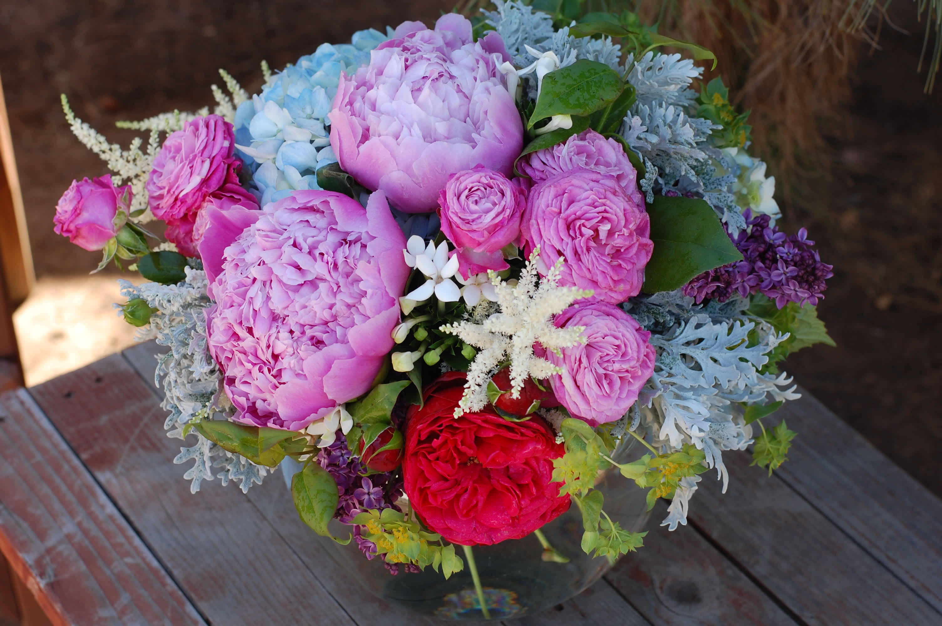 Pink and lavender bouquet with red roses in a glass vase