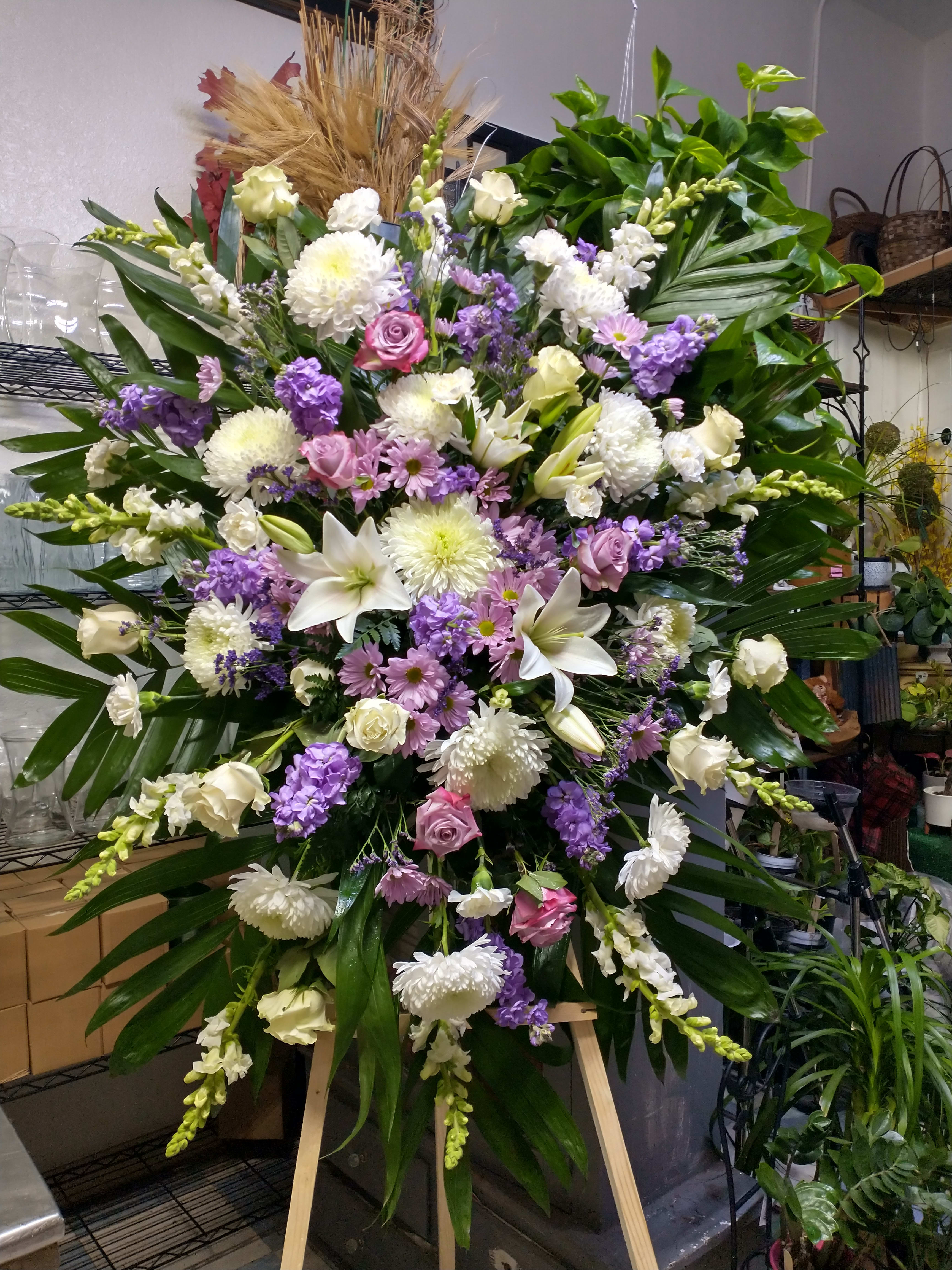 Large standing floral spray with white, pink, and purple blooms