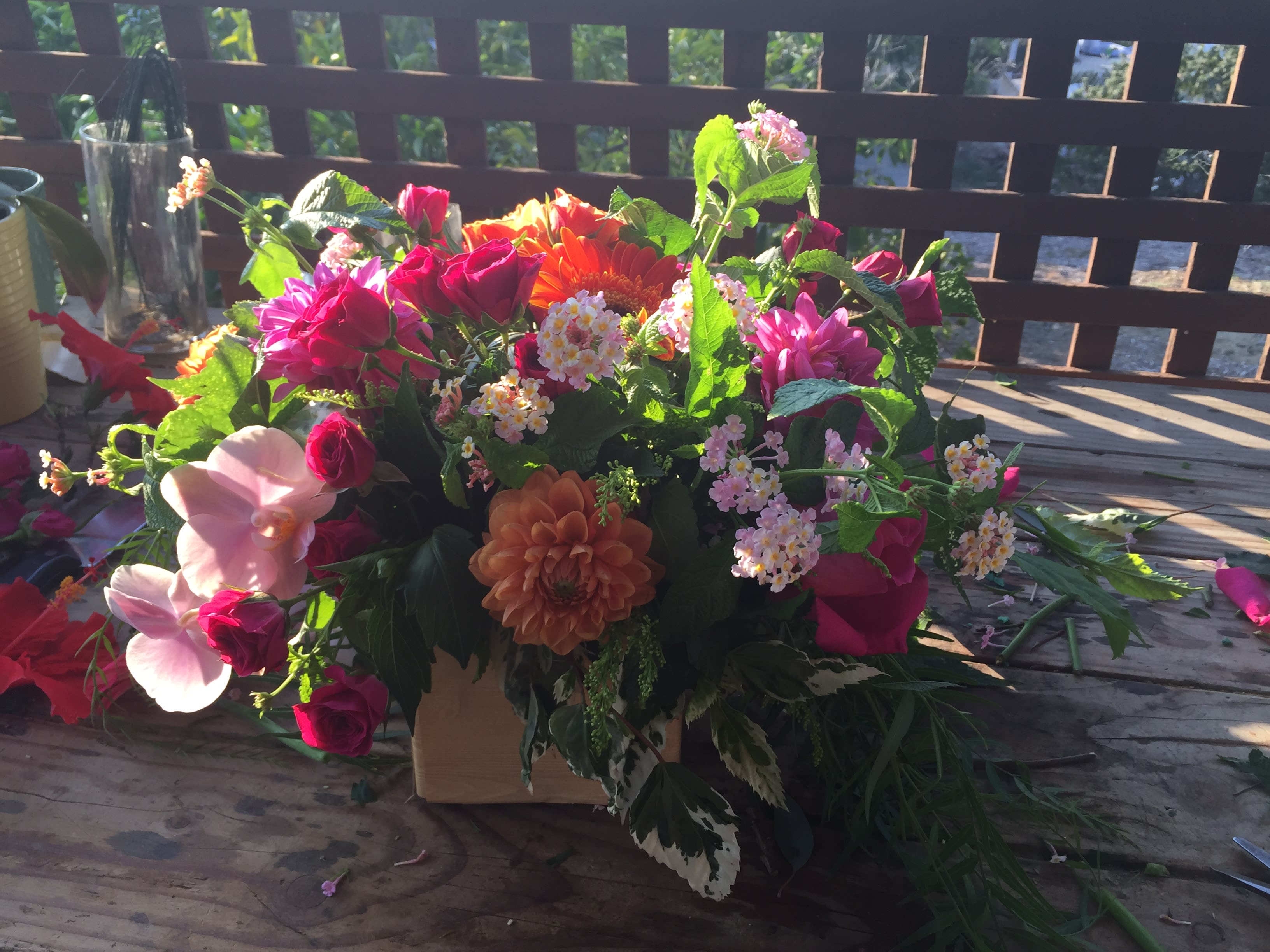 Mixed bouquet with pink and orange flowers in a low container