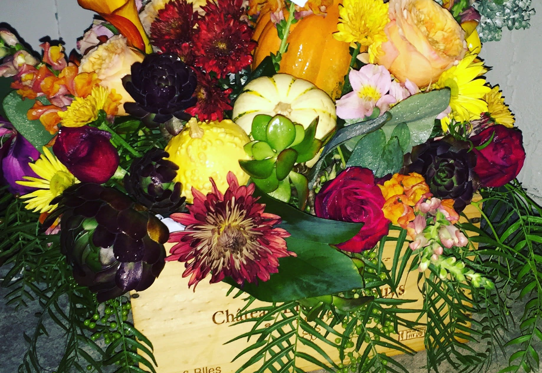 Mixed bouquet with pumpkins, roses, and chrysanthemums in a wooden box