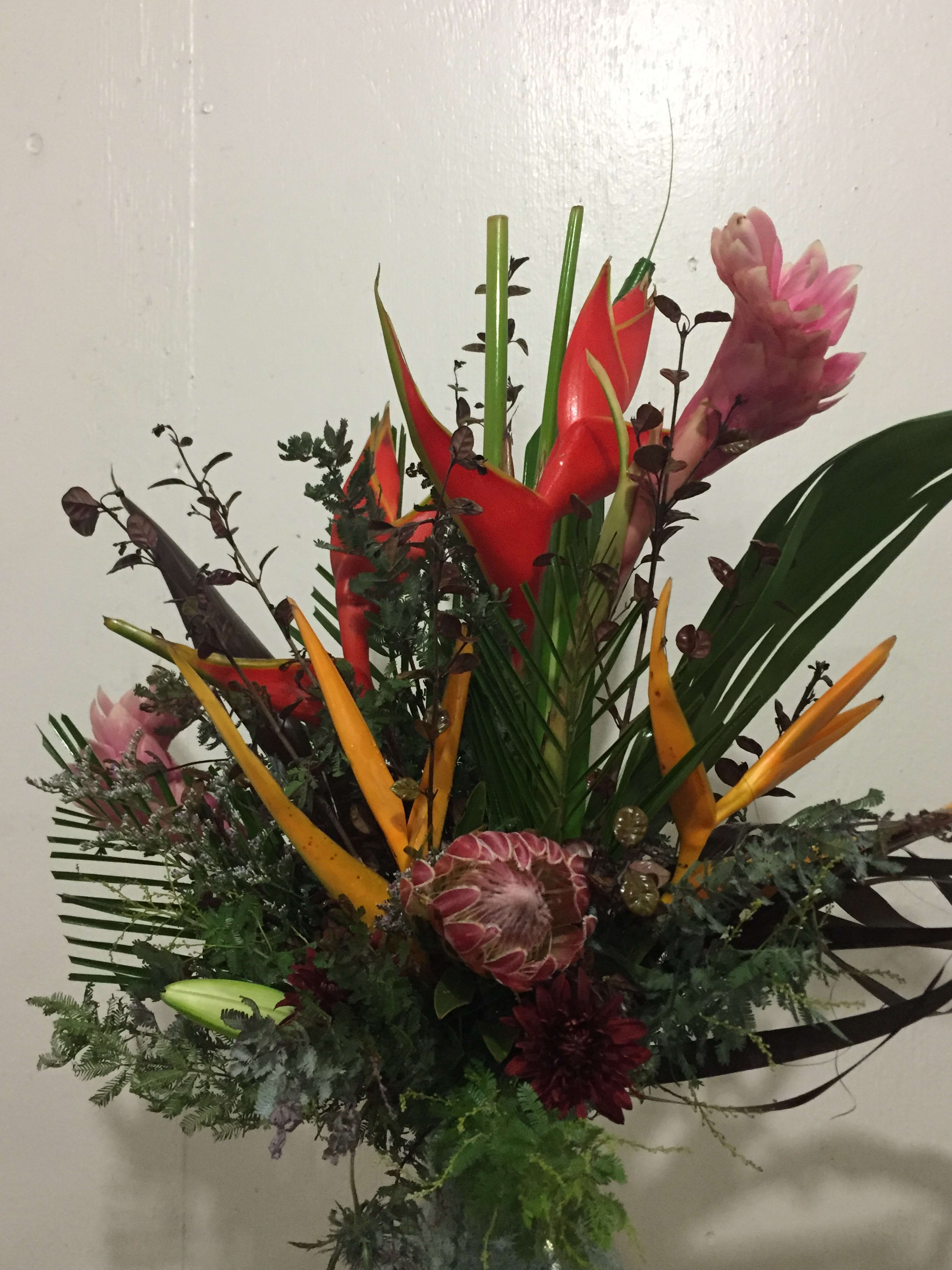 Tropical bouquet with red and orange heliconia and pink ginger flowers