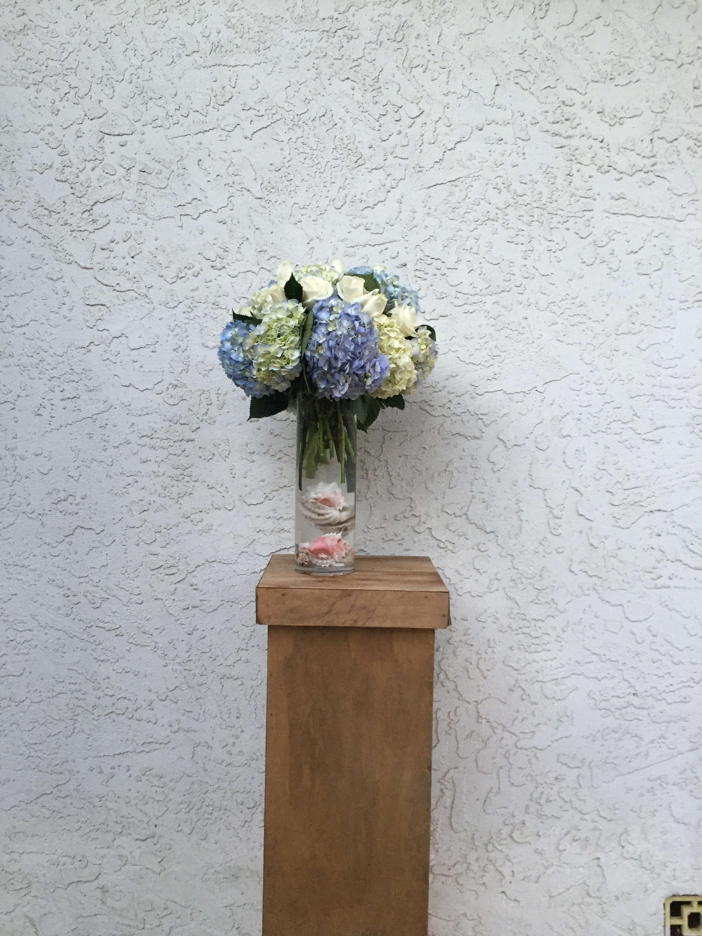 Blue and white hydrangea bouquet in a clear glass vase