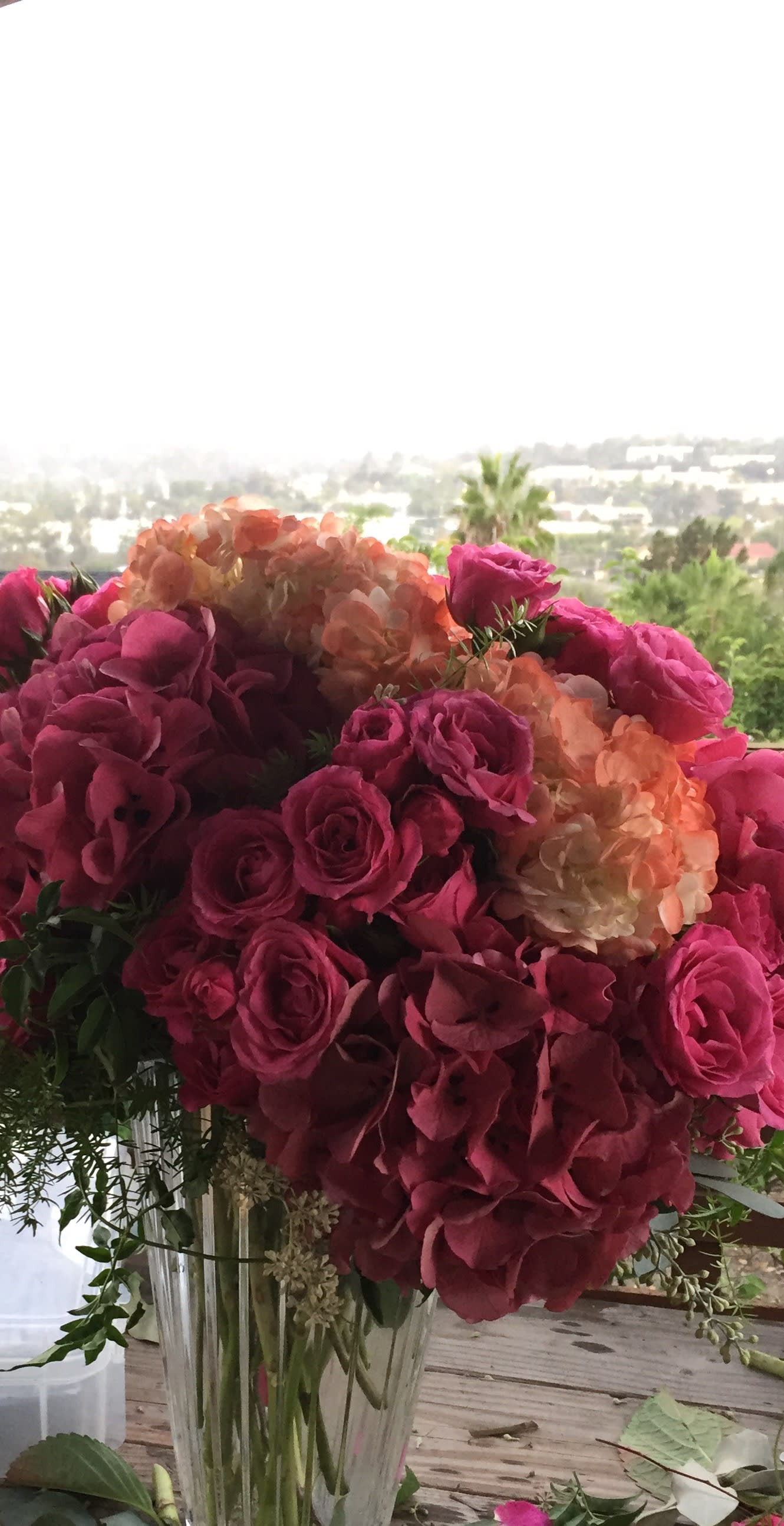 Pink roses and peach hydrangeas in a clear glass vase