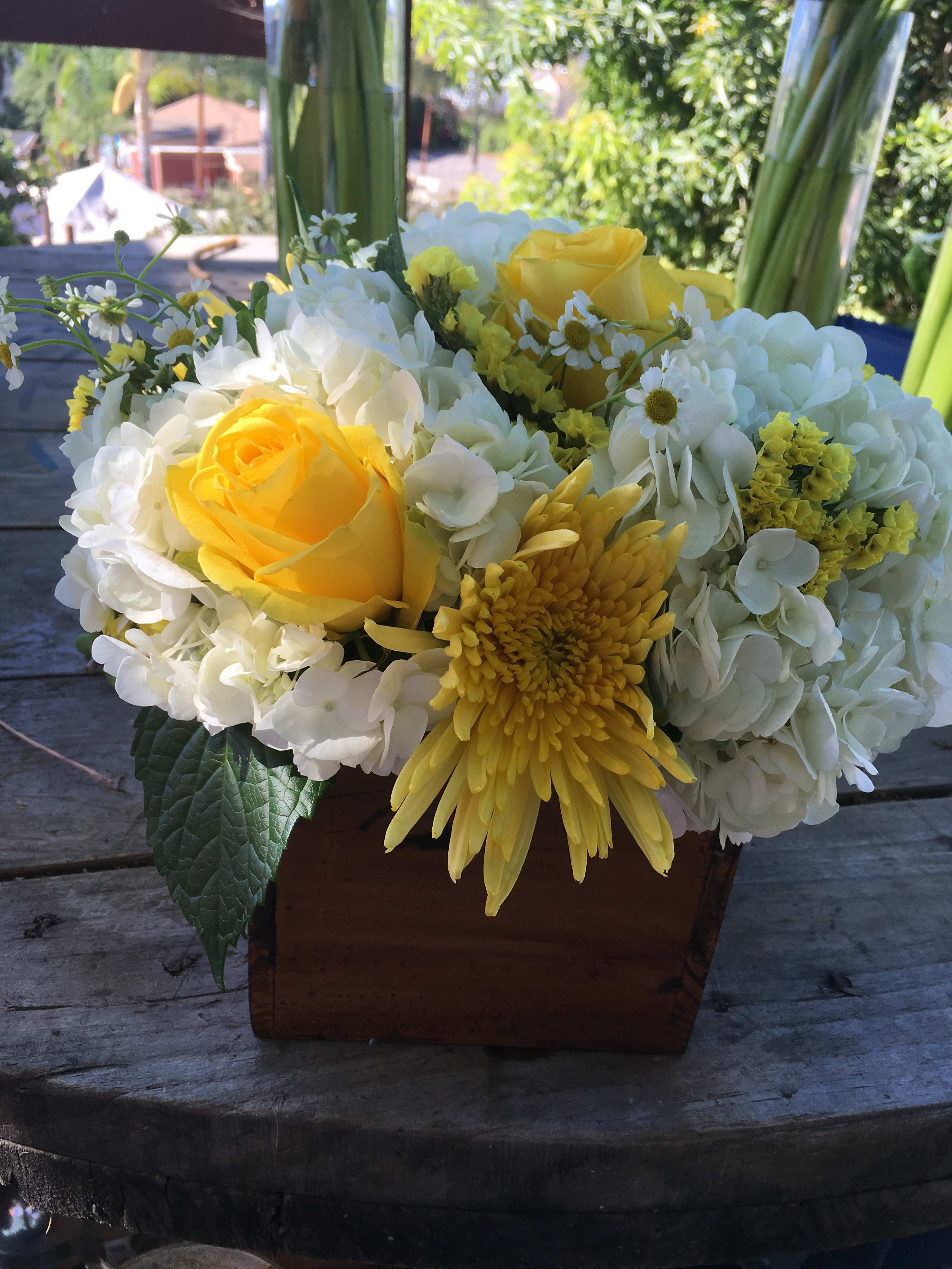 Yellow roses and white hydrangeas in a wooden box