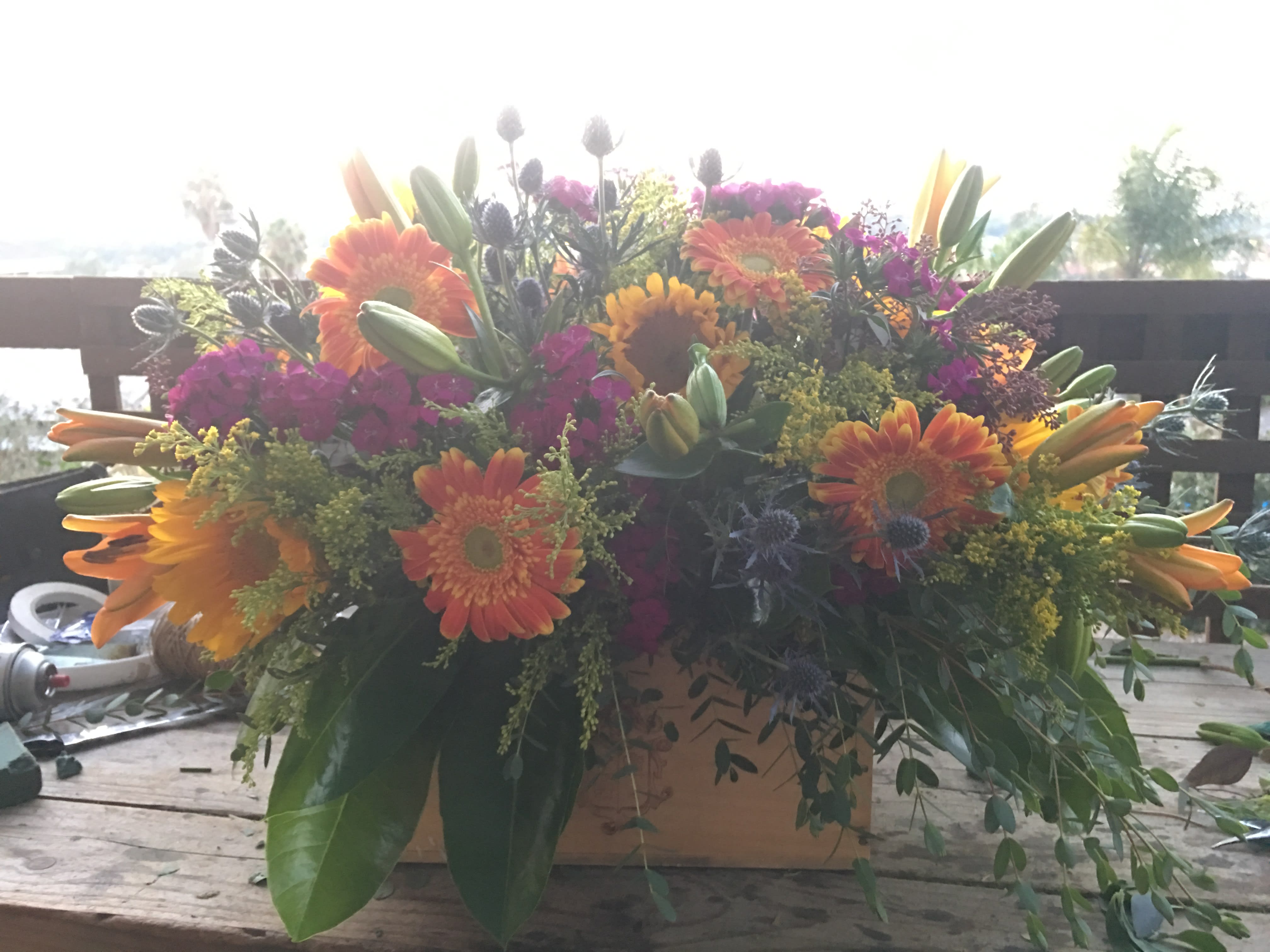 Large mixed bouquet of orange and pink flowers in a box