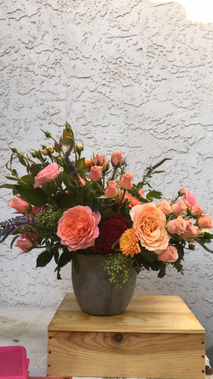 Peach and pink roses arranged in a gray vase